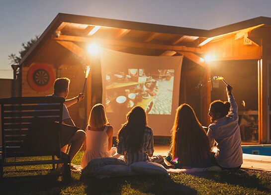Group of friends enjoying an outdoor movie night with Popsicle Jolly Rancher Sour Pops as snacks