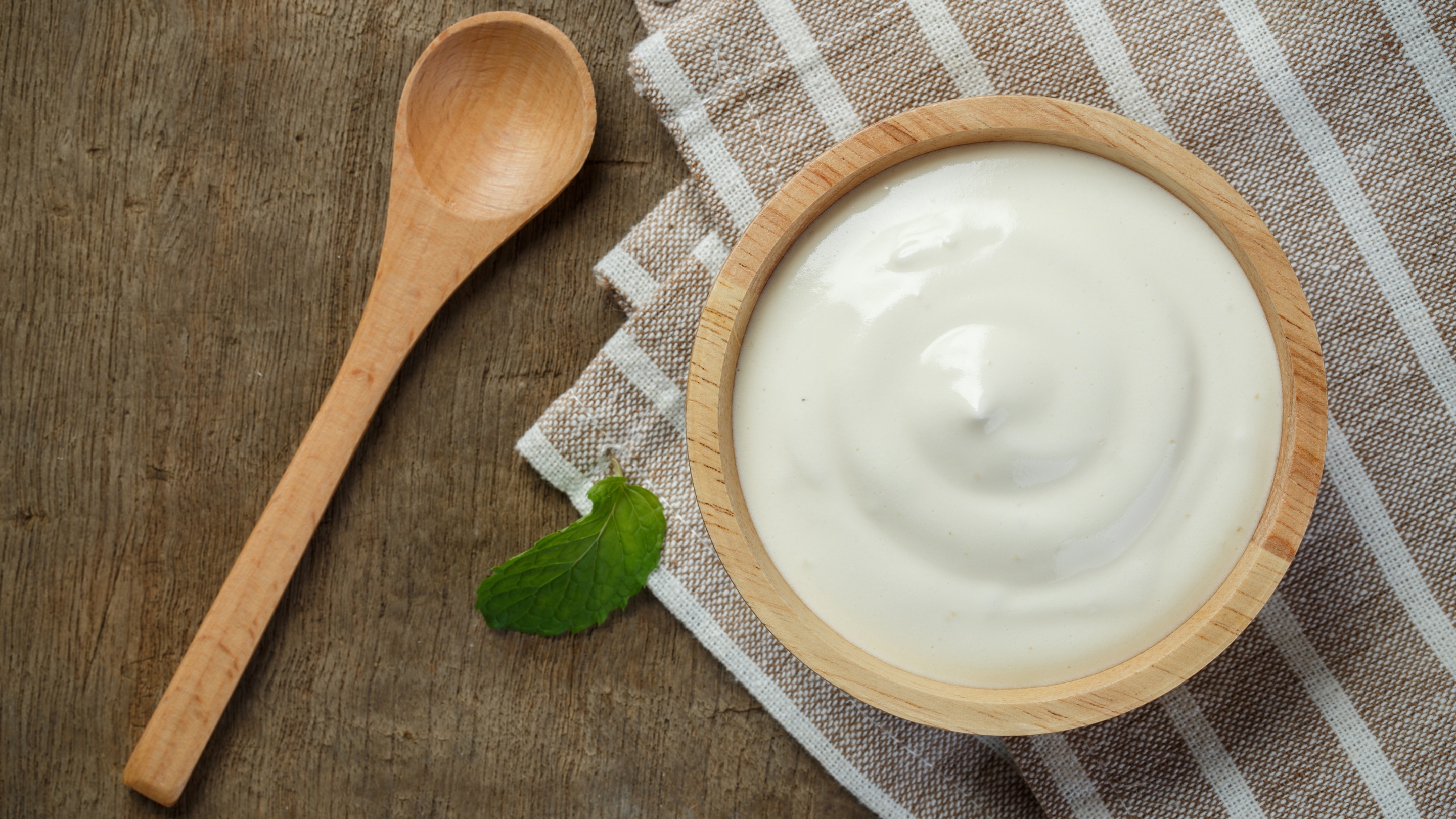 Woman applying yogurt mask on face for radiant skin