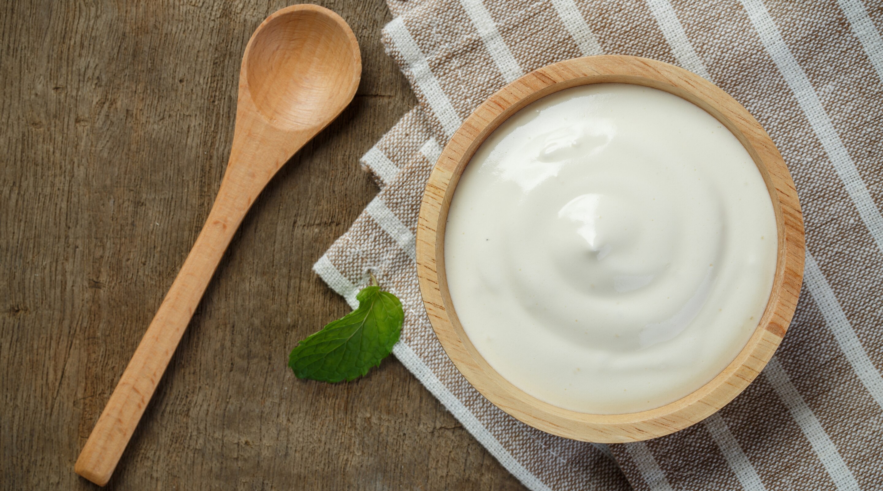 Woman applying yogurt mask on face for radiant skin