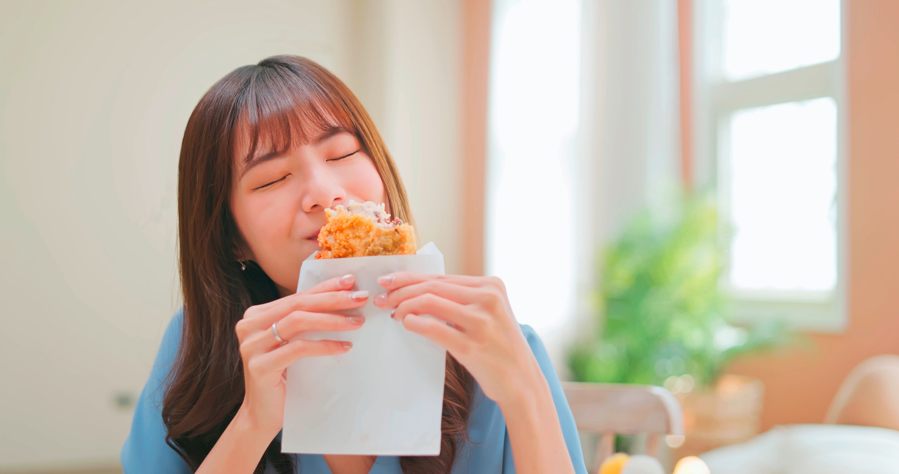 Asian woman eating fried food.