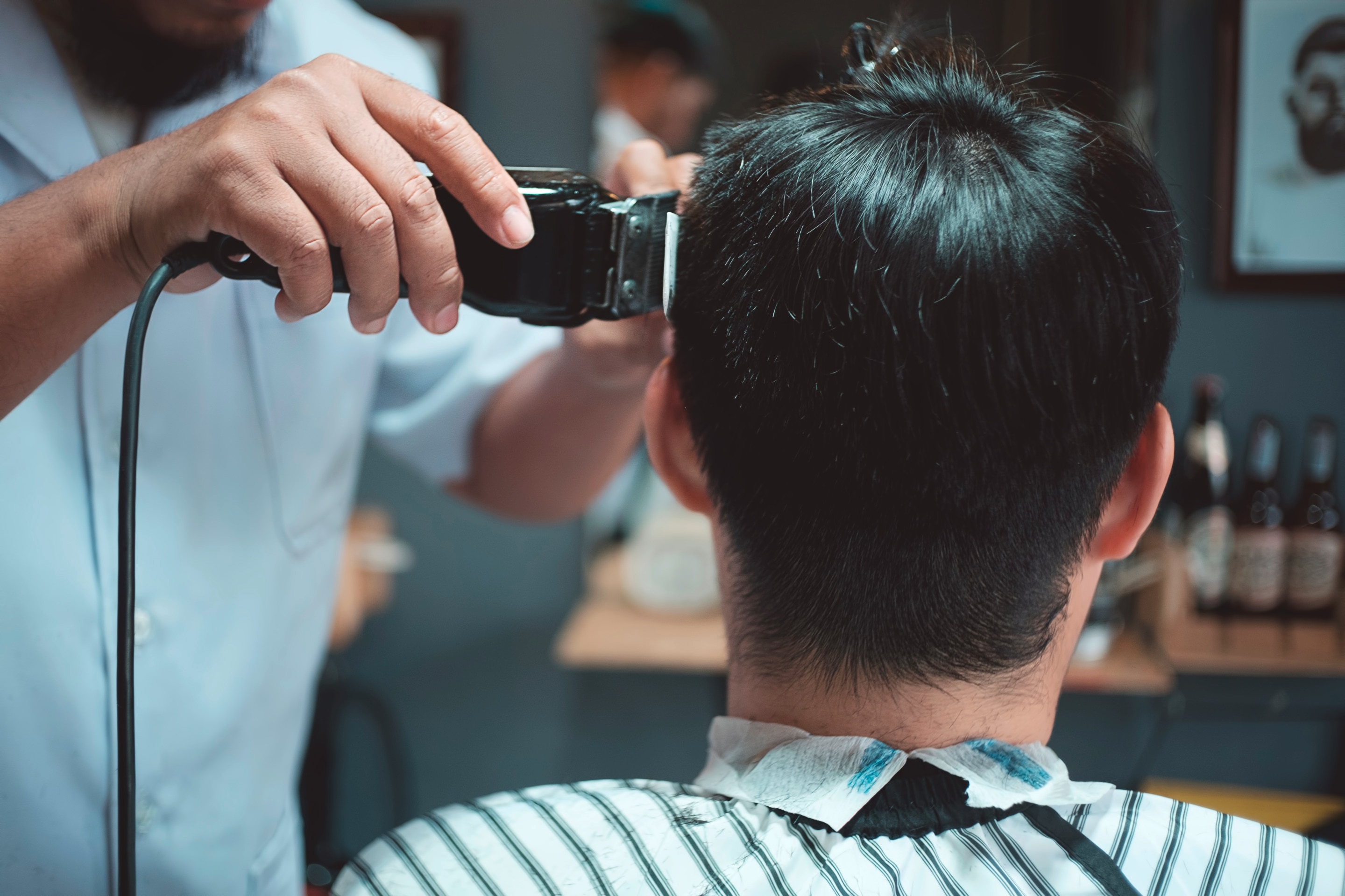 Man getting hair trimmed at barbershop.