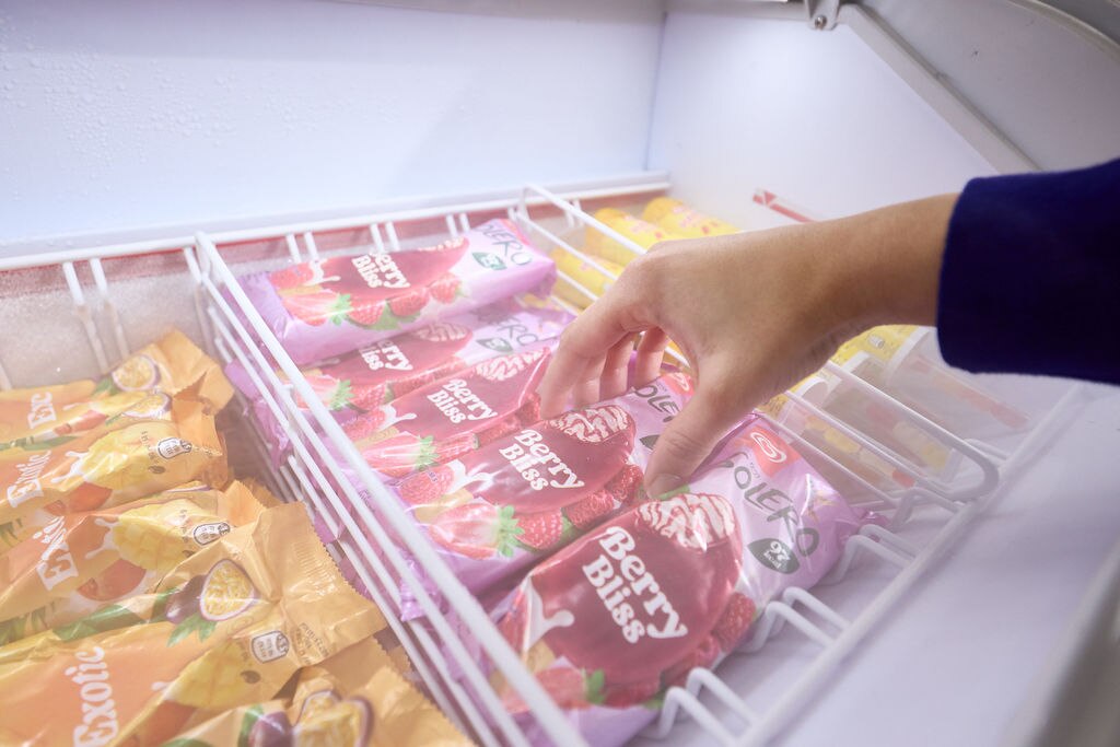 Hand reaching into an ice cream freezer to grab Solero Berry Bliss ice cream