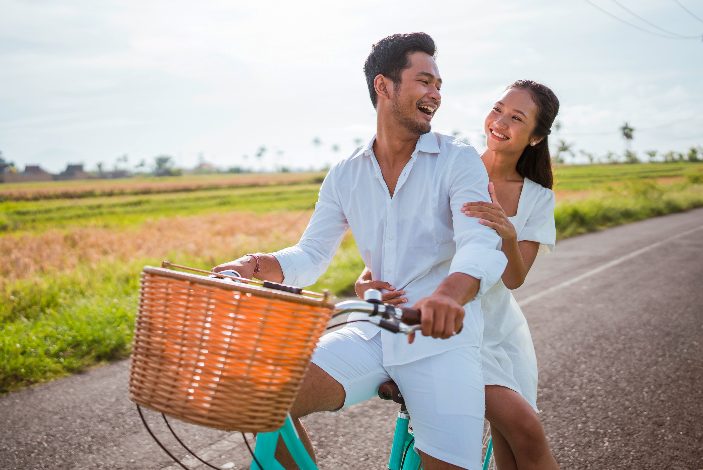Woman sits behind her boyfriend on a bike.