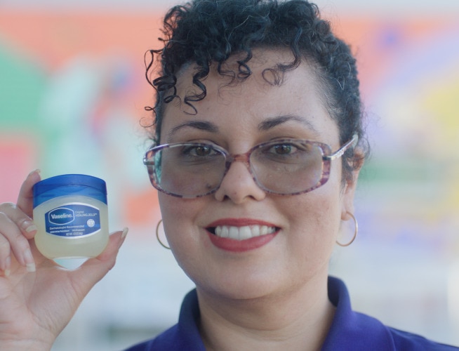 Close-up of a woman holding a mini Vaseline Healing Jelly