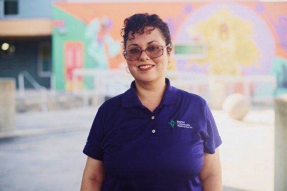 A woman happily posing and smiling for a photoshoot