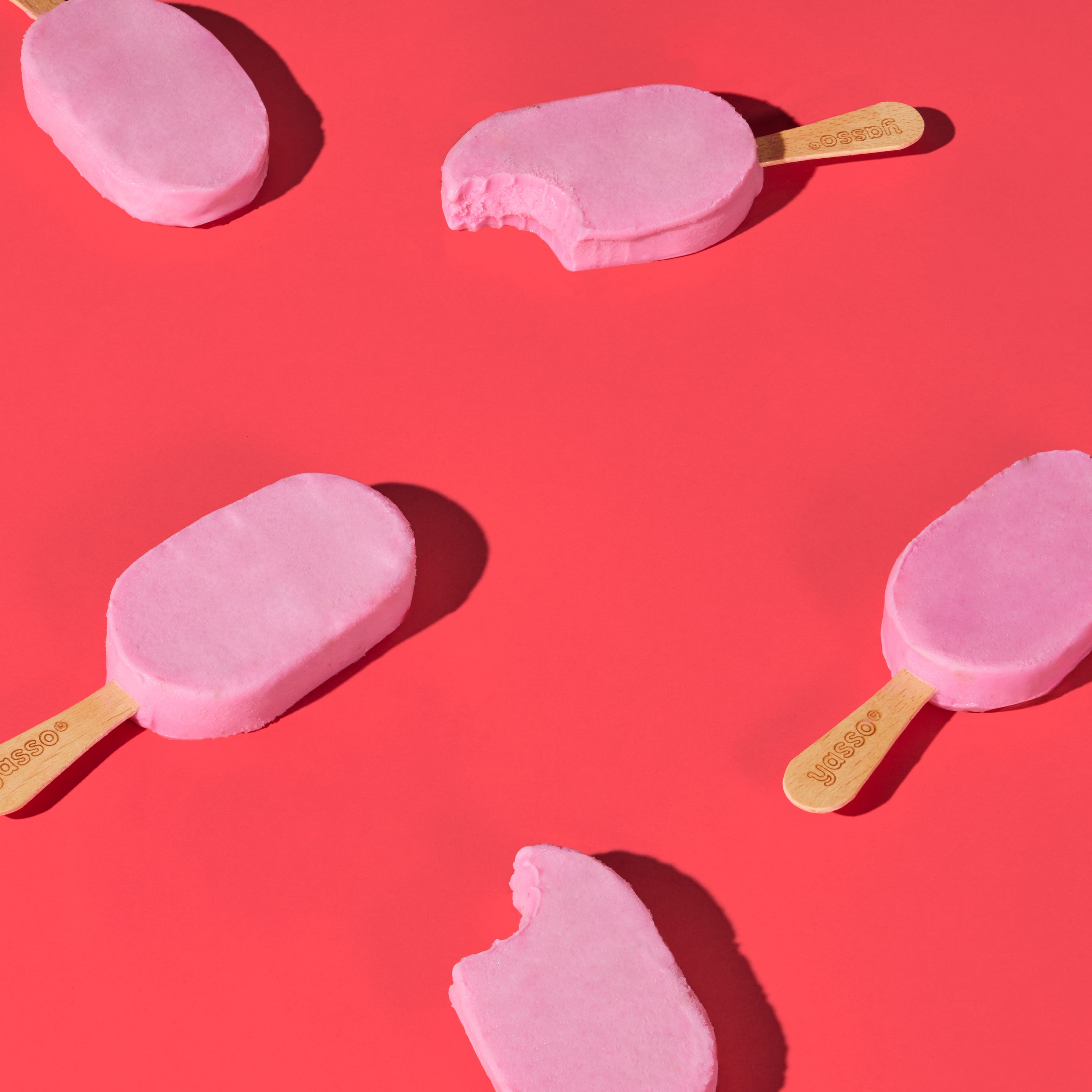 Yasso strawberries and cream bars against a pink background