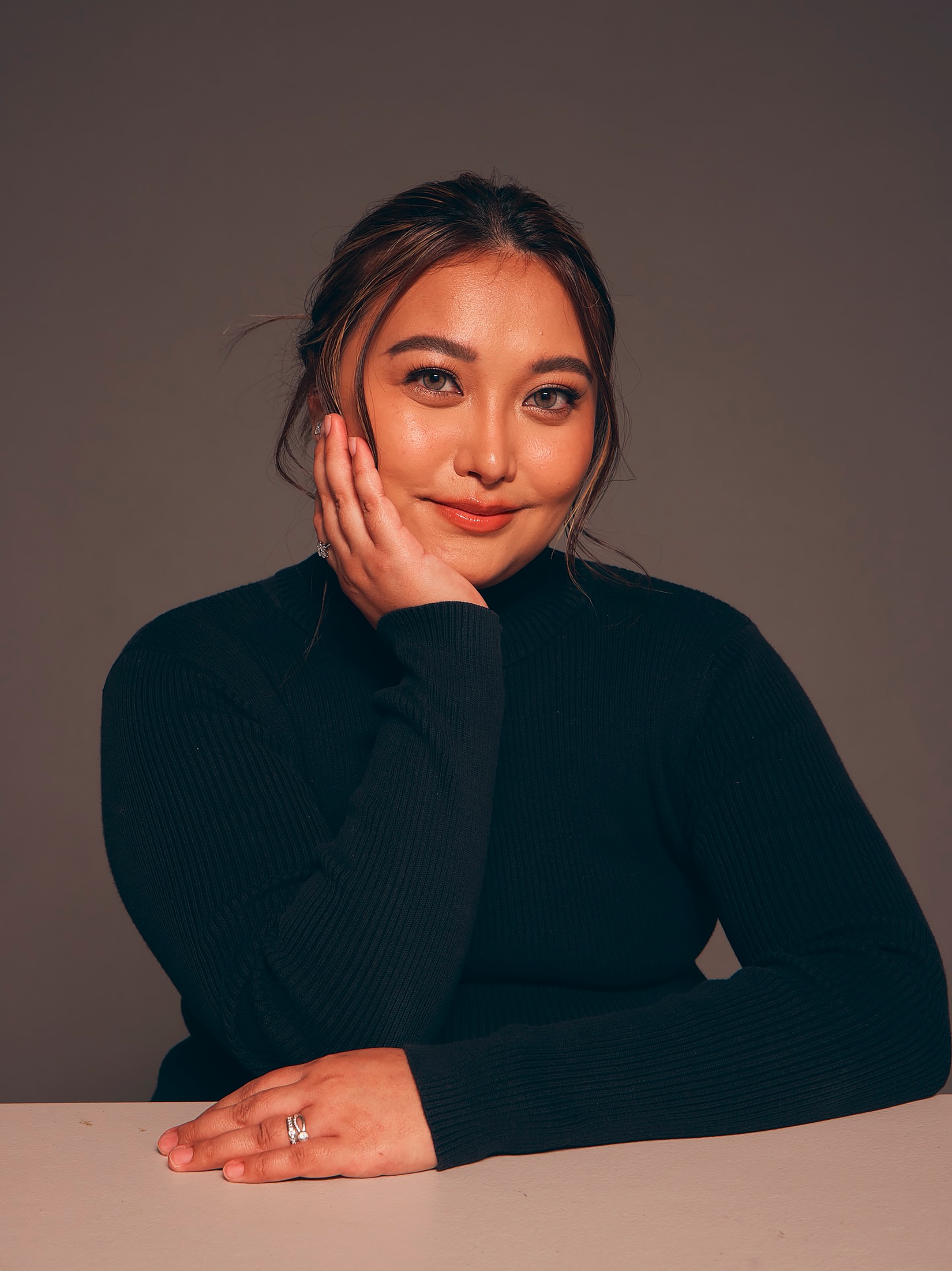 Smiling asian woman in a turtleneck.