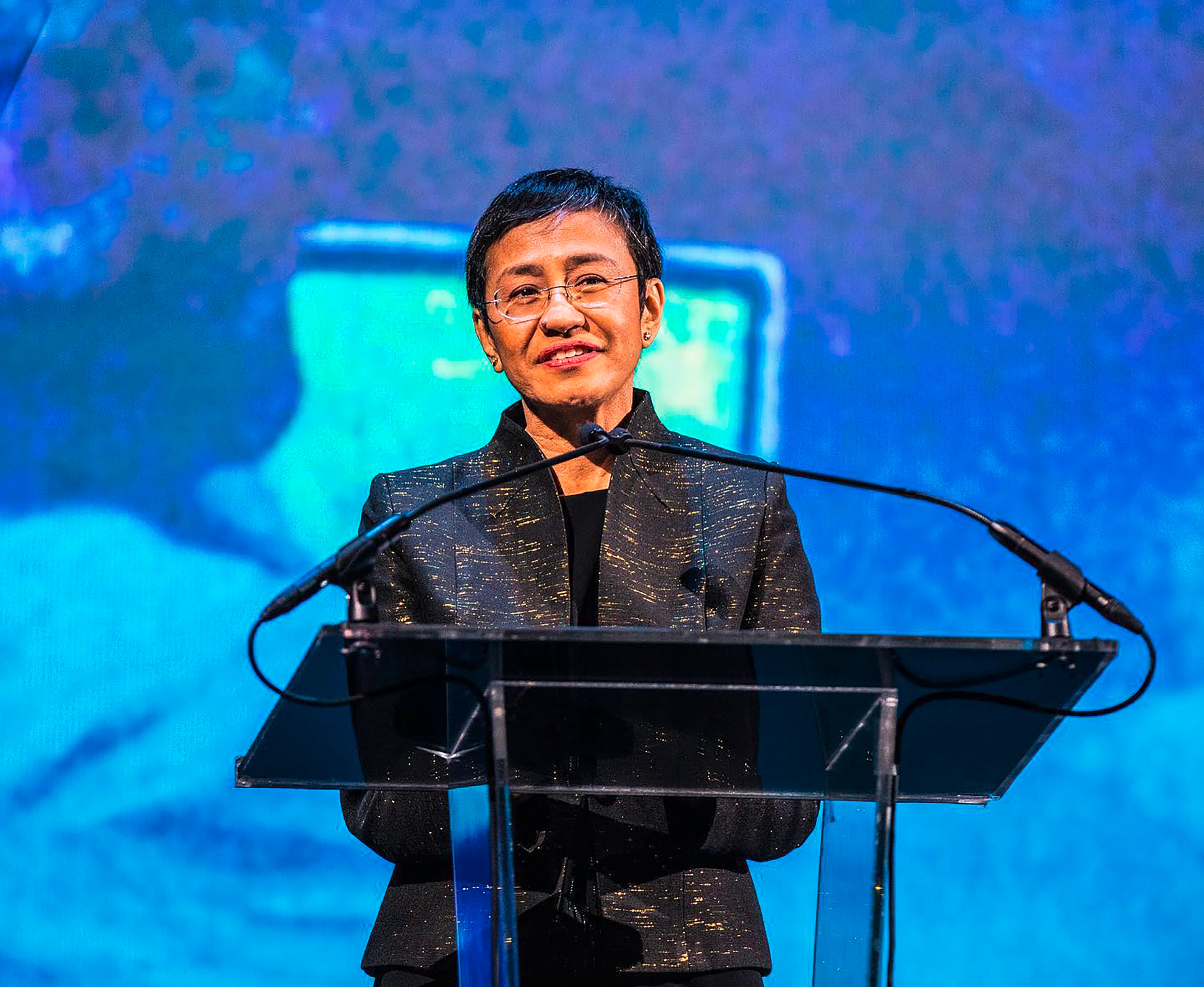 Asian woman making a speech on stage.