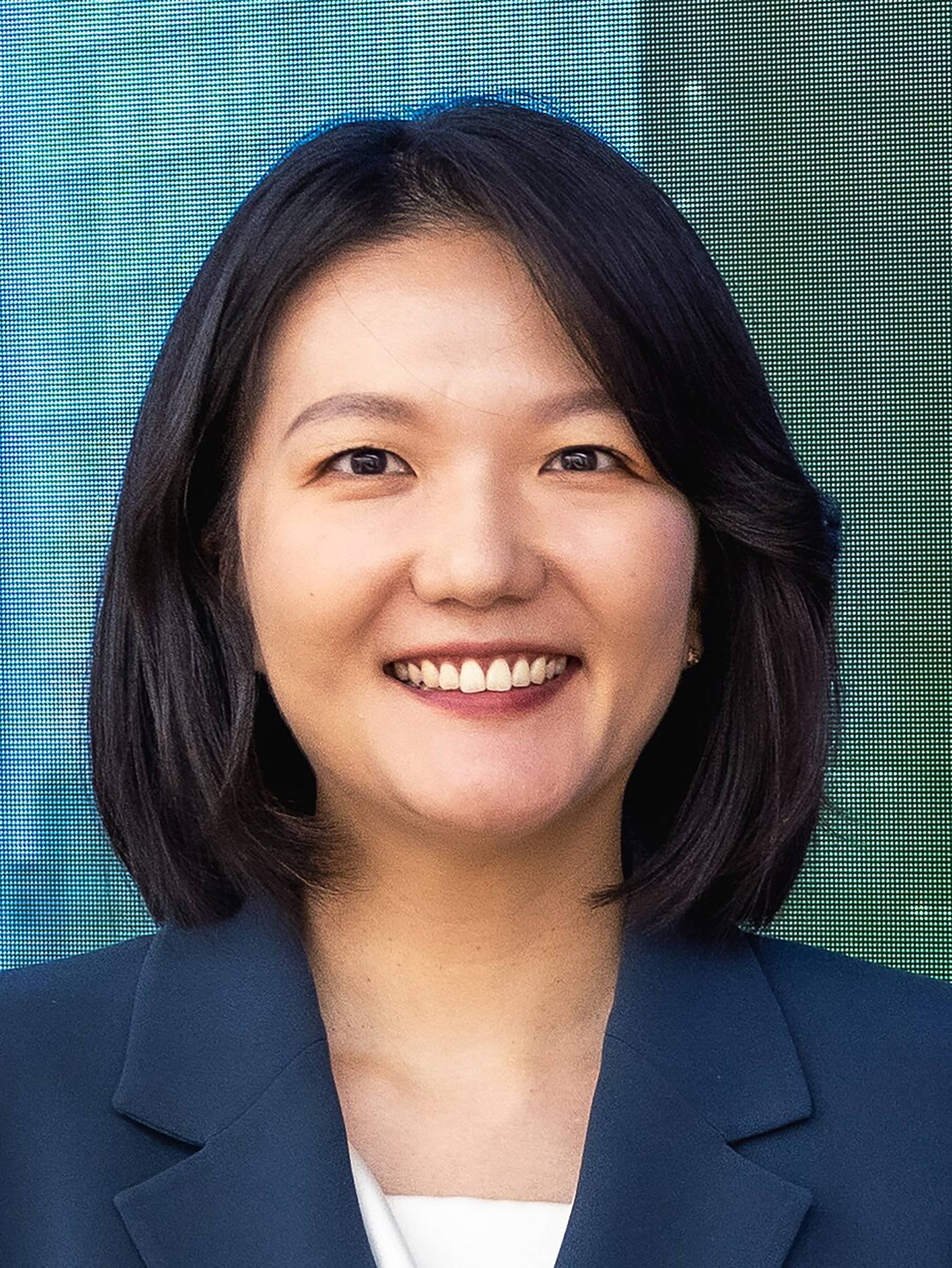 Headshot of smiling Korean woman in a blazer.