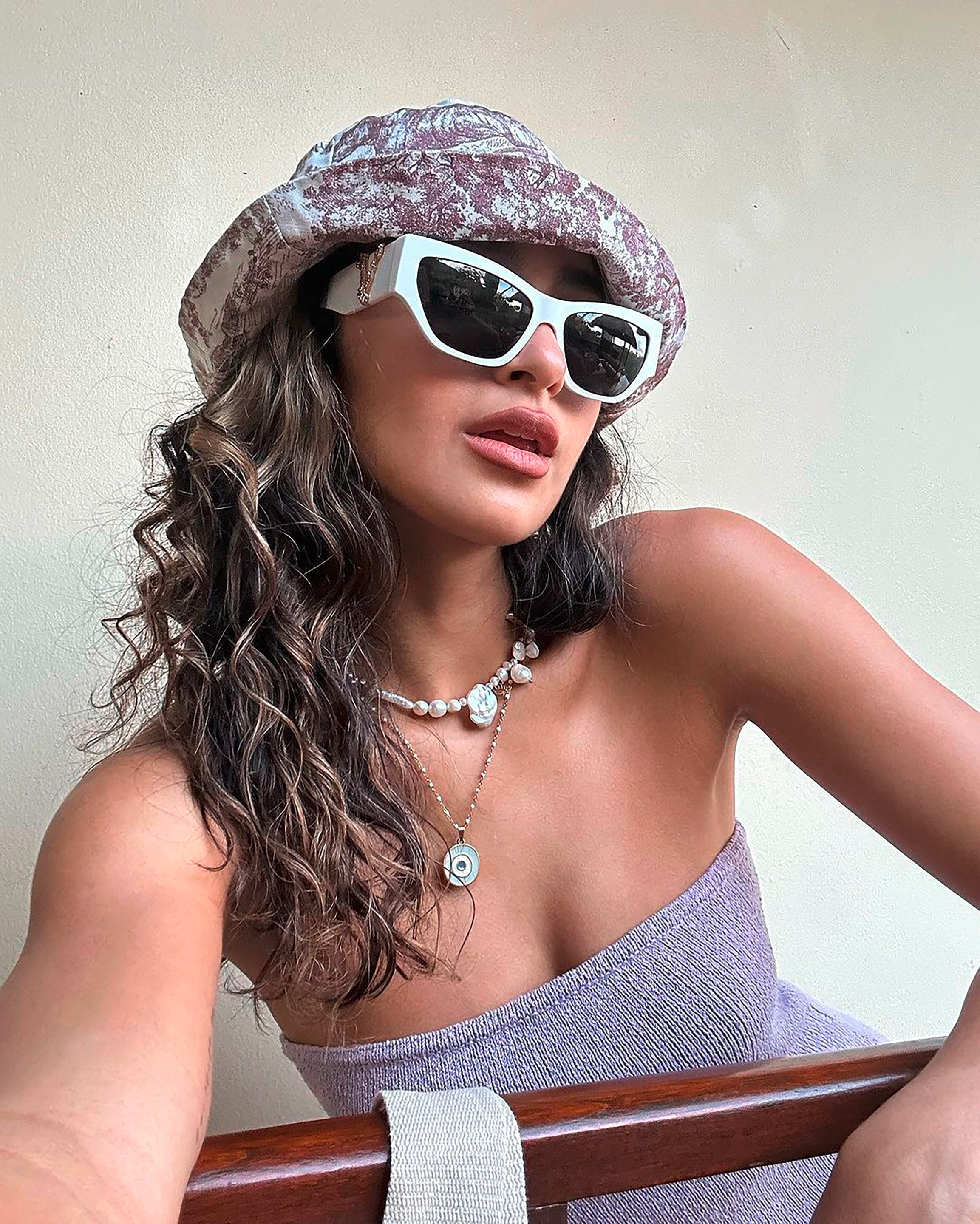 A selfie of woman with naturally curly hair and blonde baby hairlights.