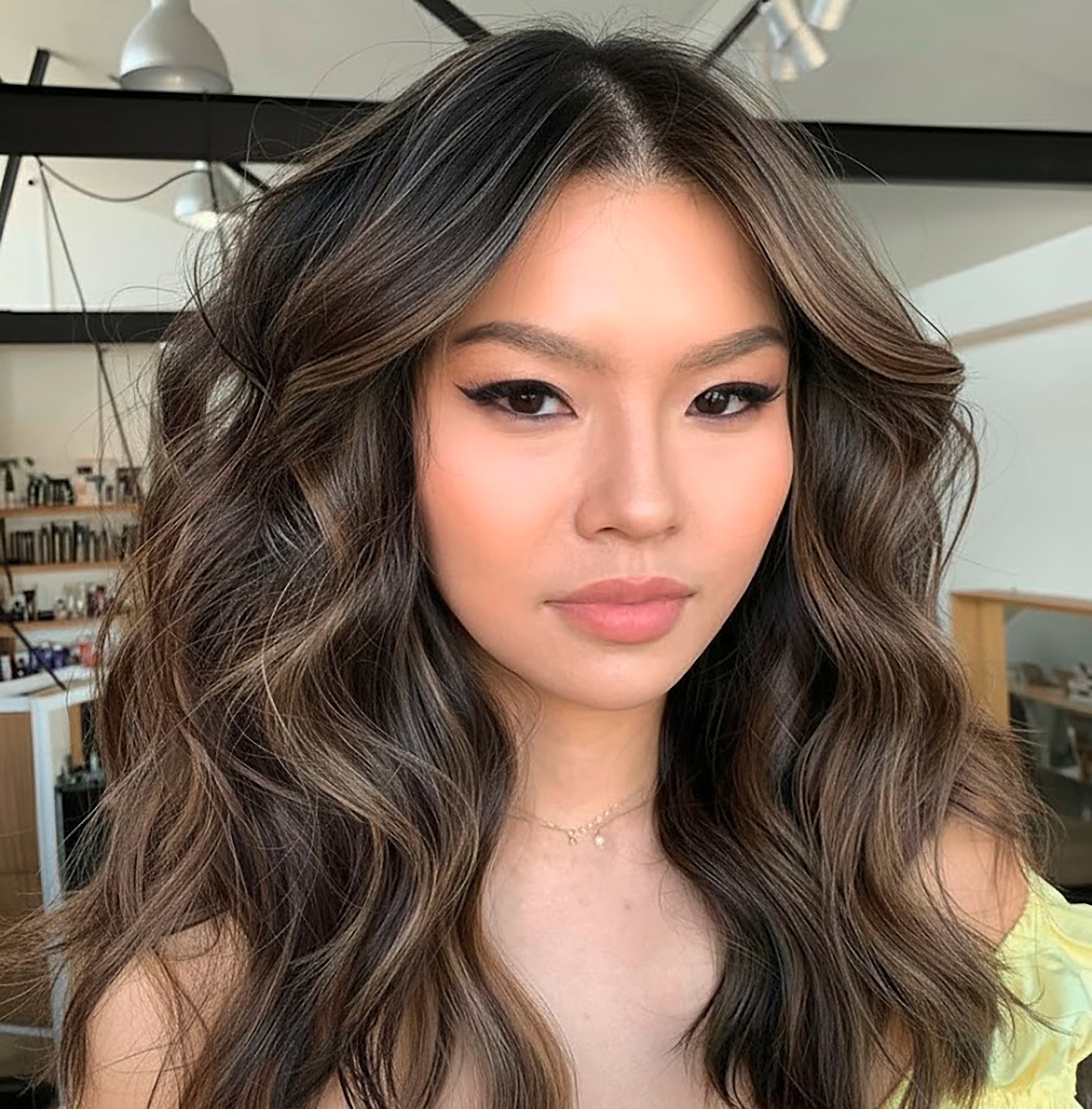 Woman with wavy hair and light brown highlights.