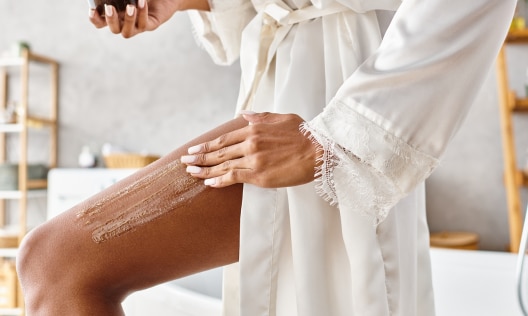 African American woman using African Black Soap Sugar Scrub to exfoliate her body