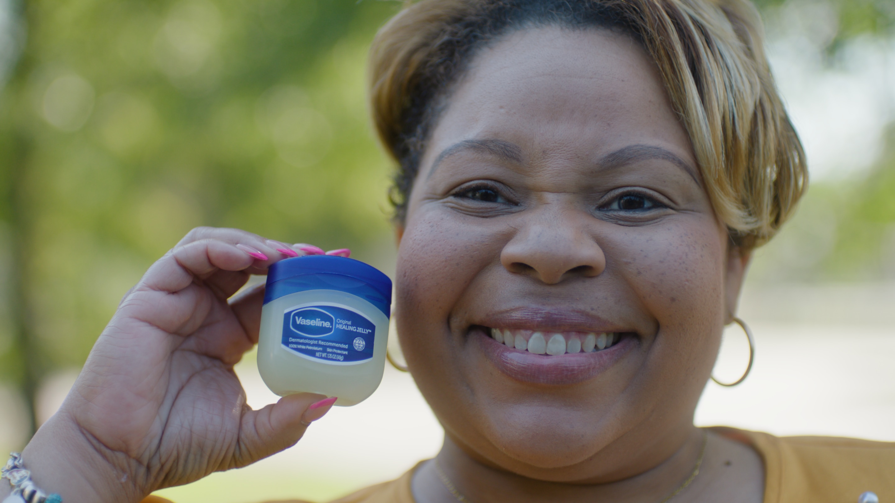 A woman holding a jar of Vaseline Healing Jelly