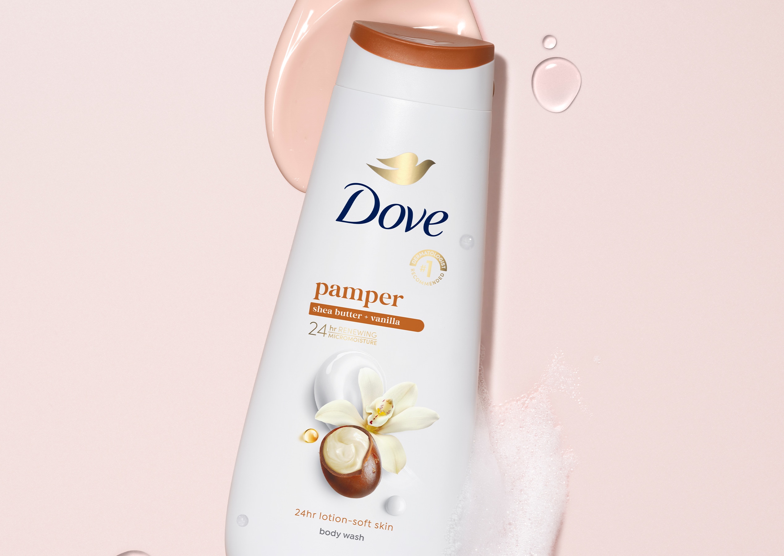 Dove Pamper Body Wash bottle laid on a pink background with spots of product placed next to it