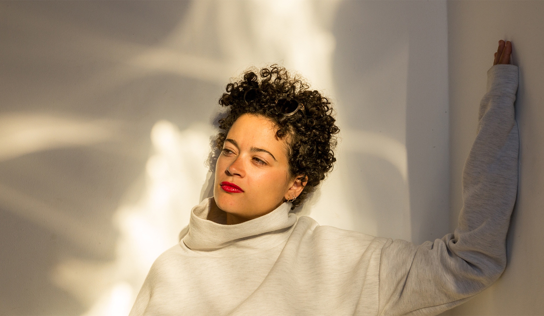 Woman looking off to the left had side, with face bathed in sunlight