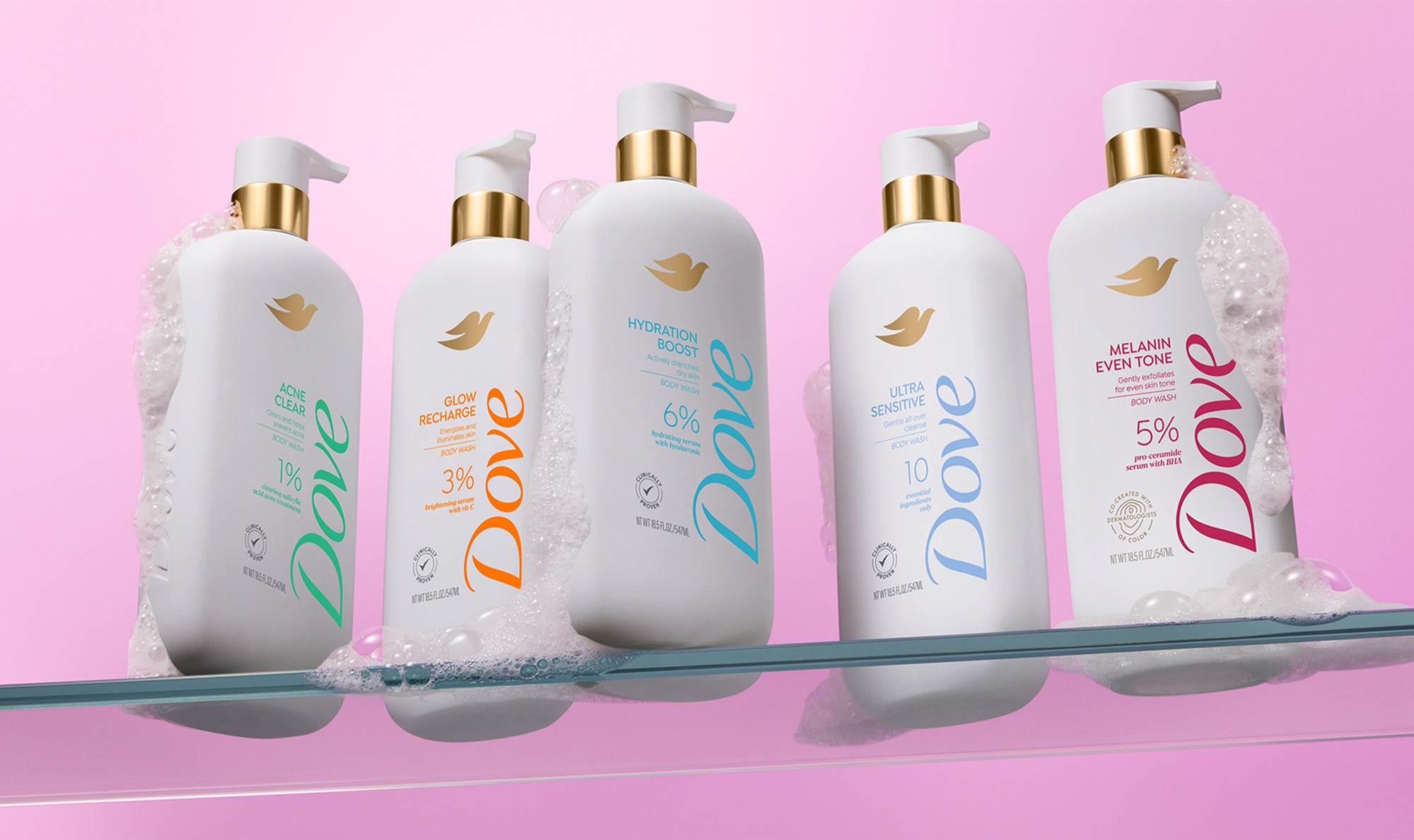 Product line up of five Dove body wash bottles in a row against a pink background