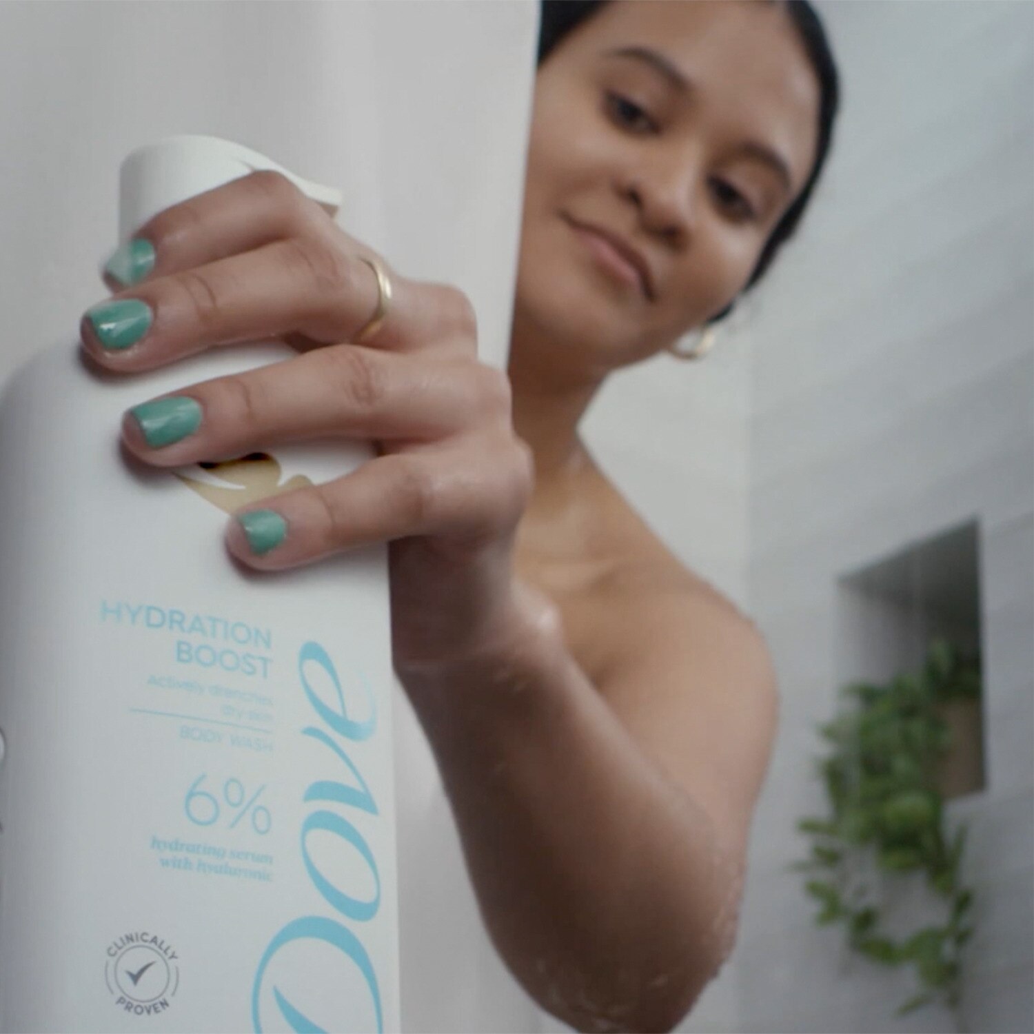 Woman grabbing Dove Hydrating Serum Body Wash in the shower