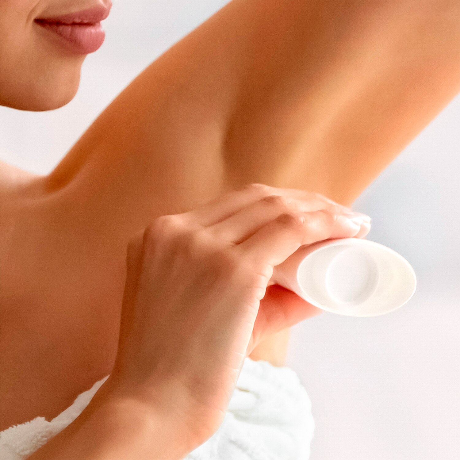 Image of woman applying Deodorant stick to underarm