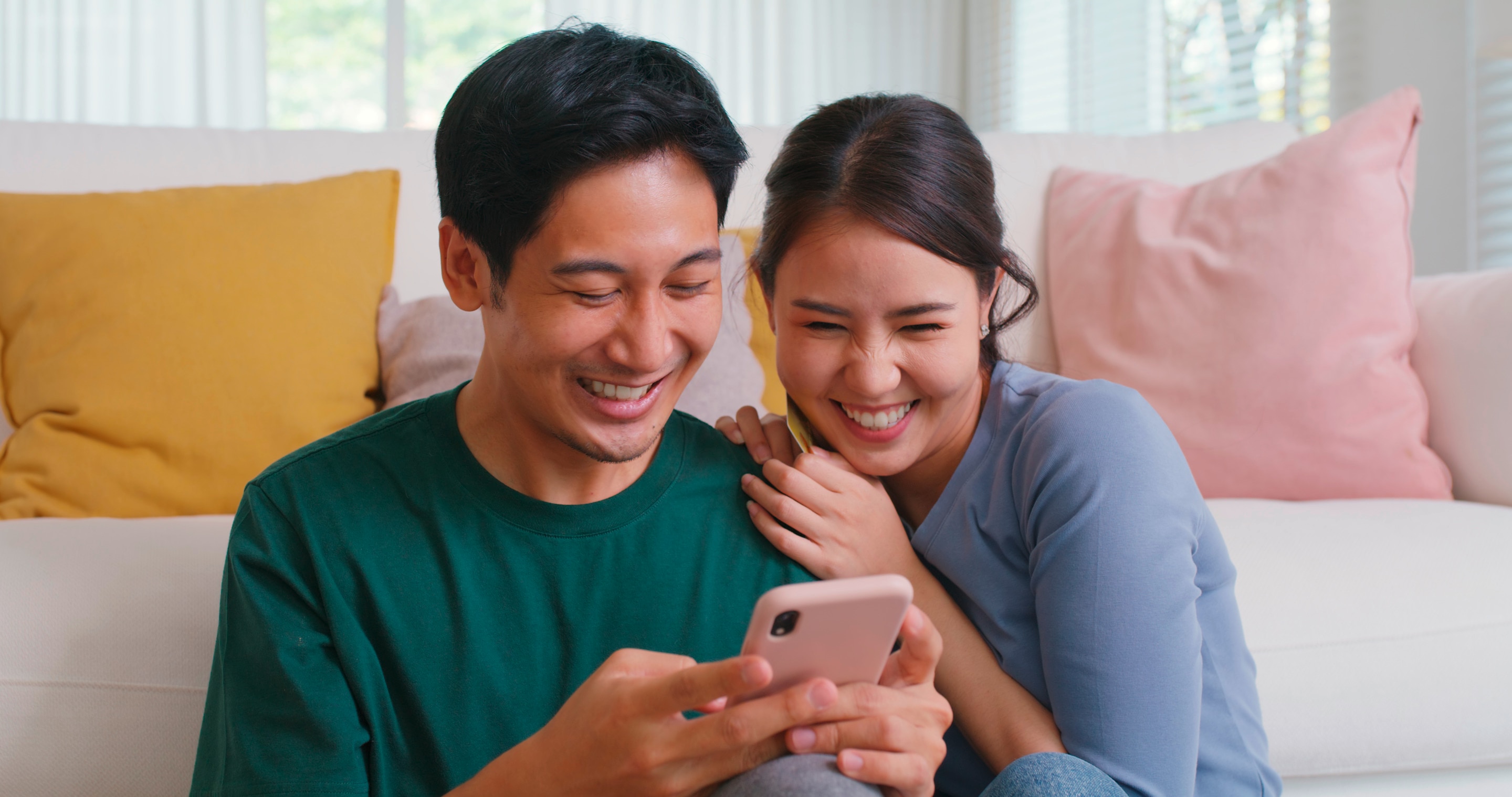 Asian couple looking at phone together.