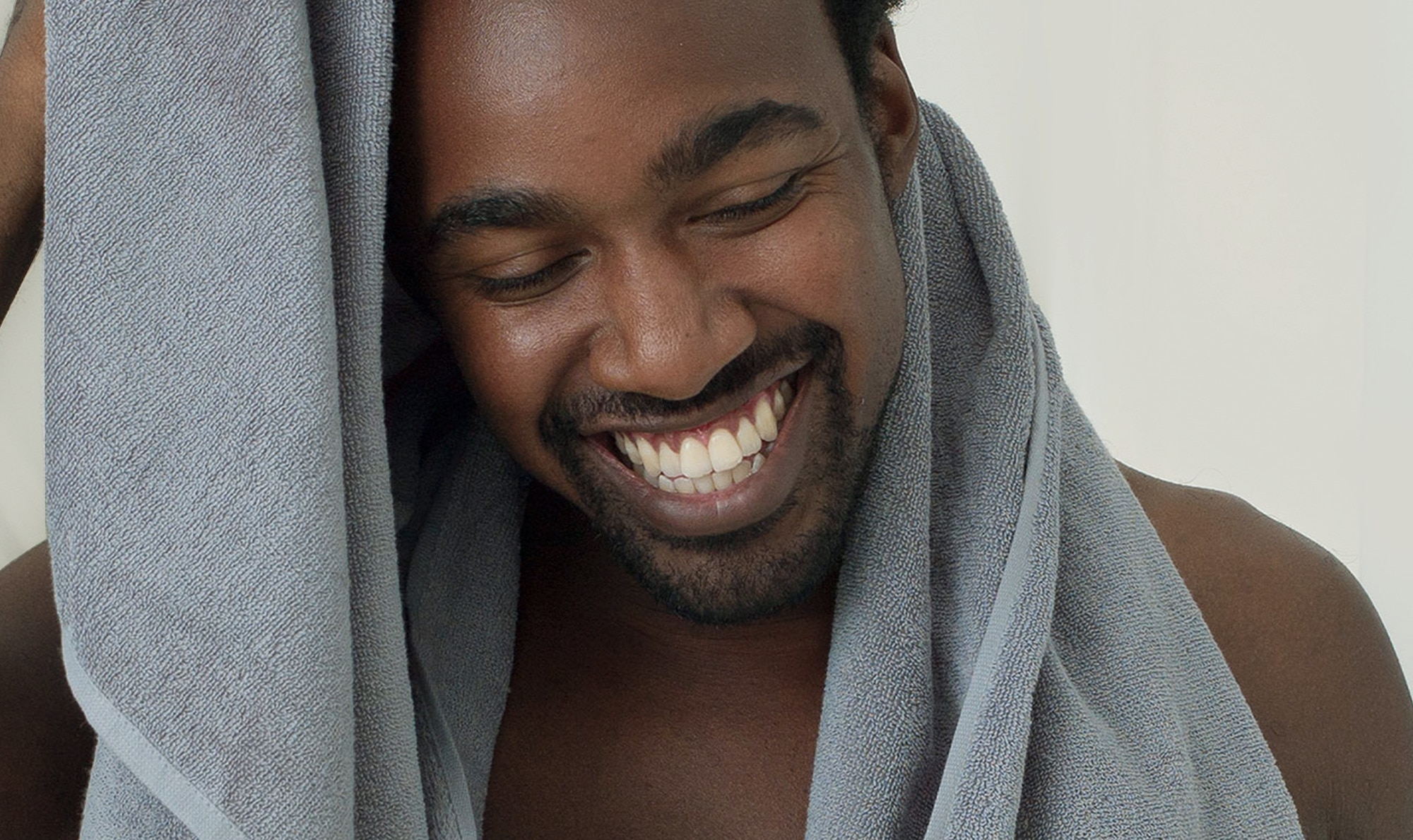 Man smiling and drying himself with a towel.