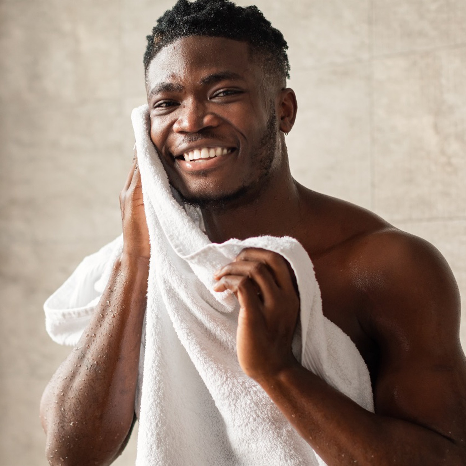 Man drying his face on a towel while smiling