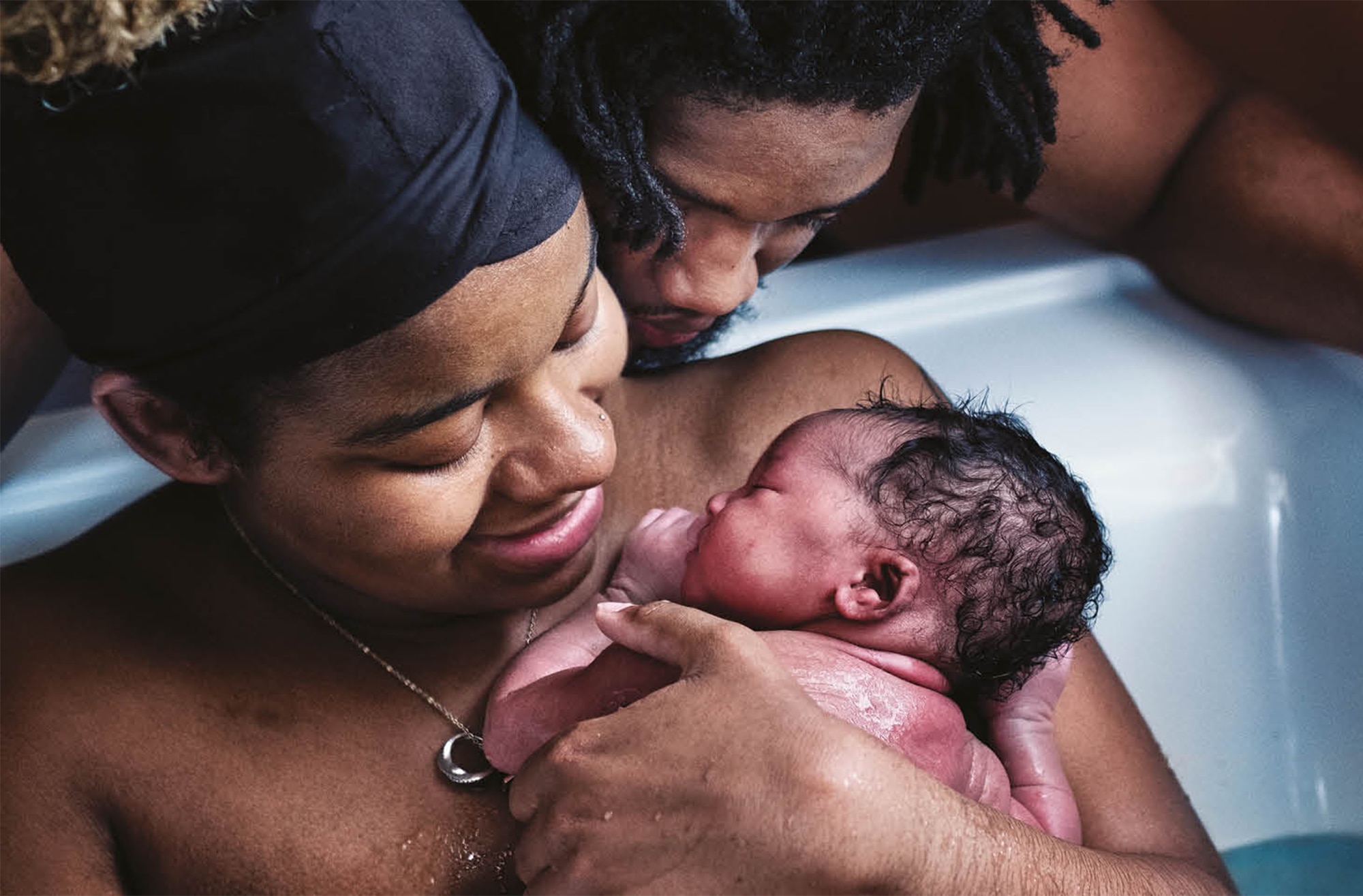 Image of a mother cradling her newborn baby in a birthing pool