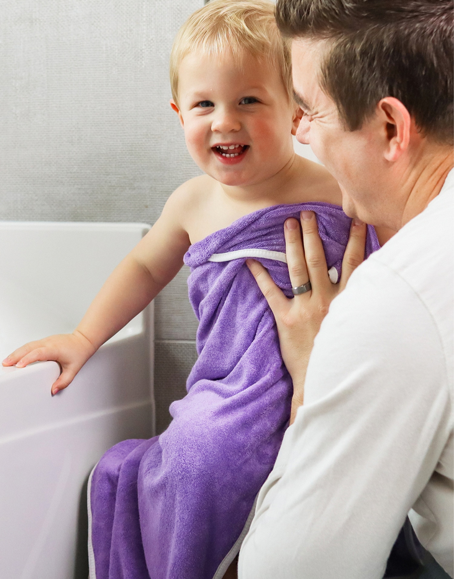 Man drying a baby with a purple towel