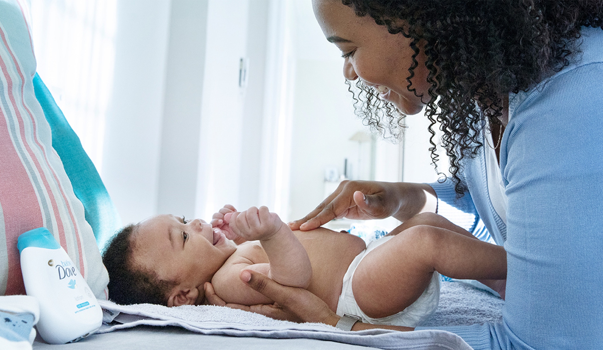 Image of a mother smiling down at her baby on a changing mat