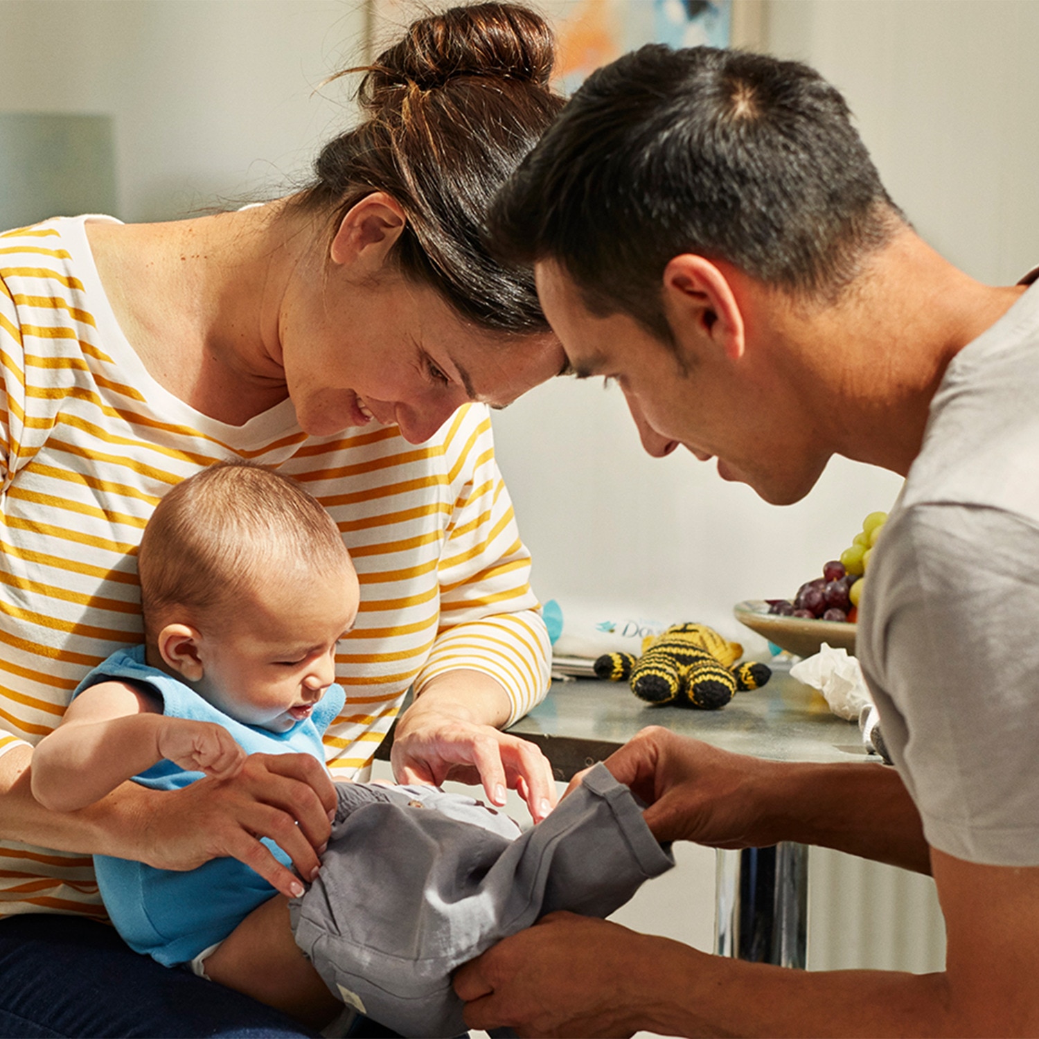 Mother and father dressing their baby