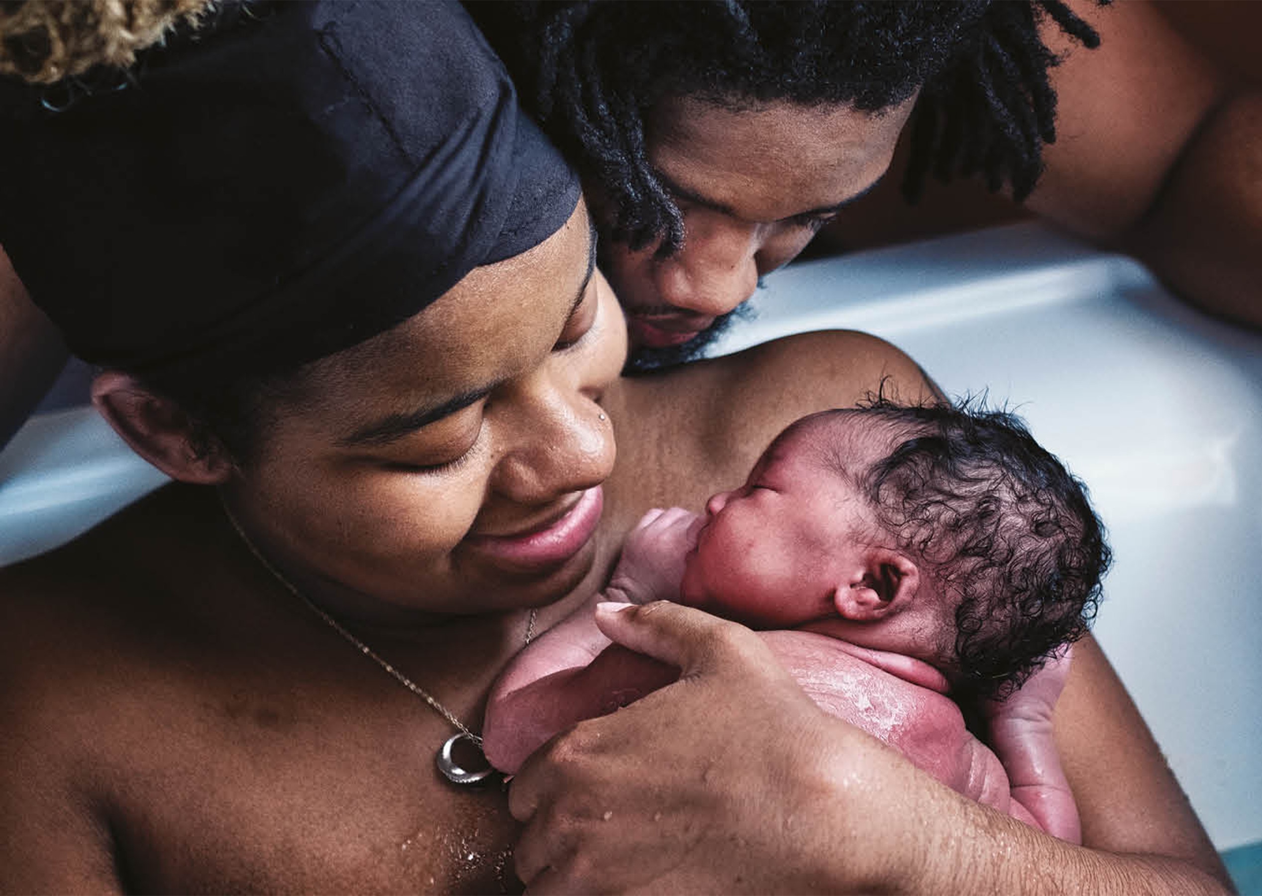 Mother holding her newborn in the birthing pool