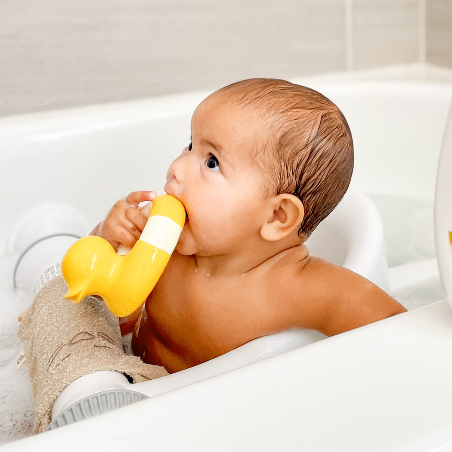 Image of a baby chewing on a yellow bath toy