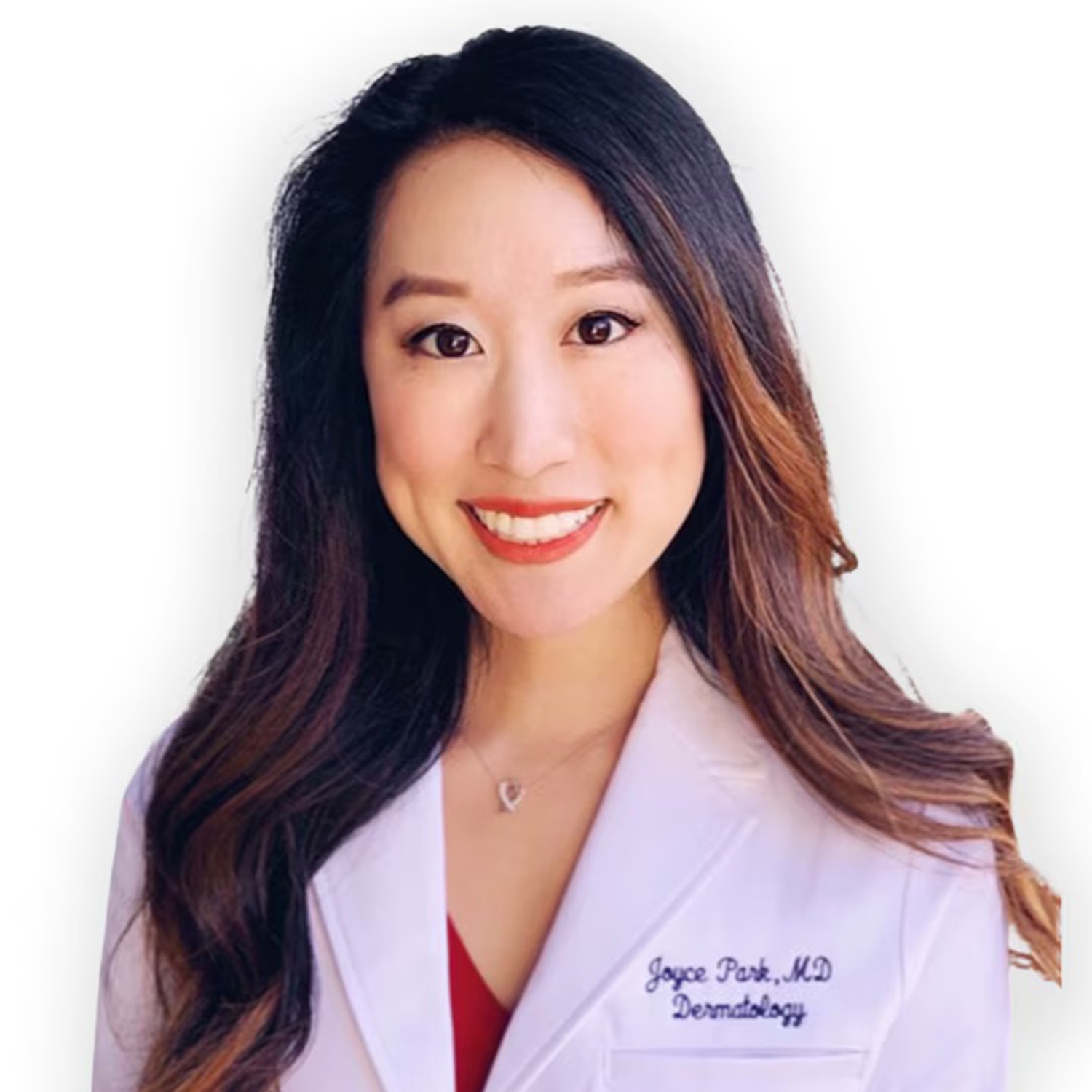 A dermatologist in work attire smiling at the camera