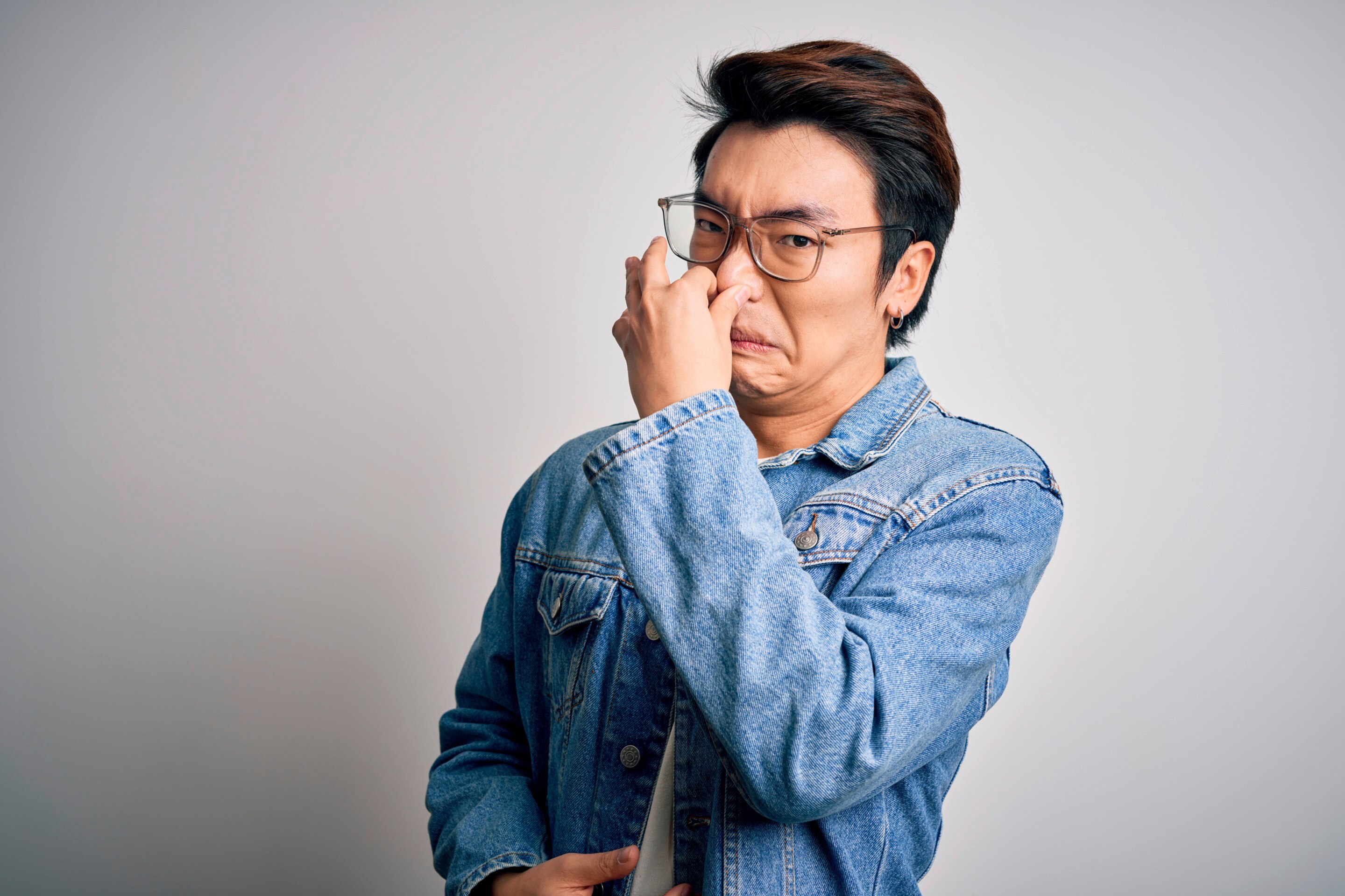 Pria Asia sedang menutup hidung