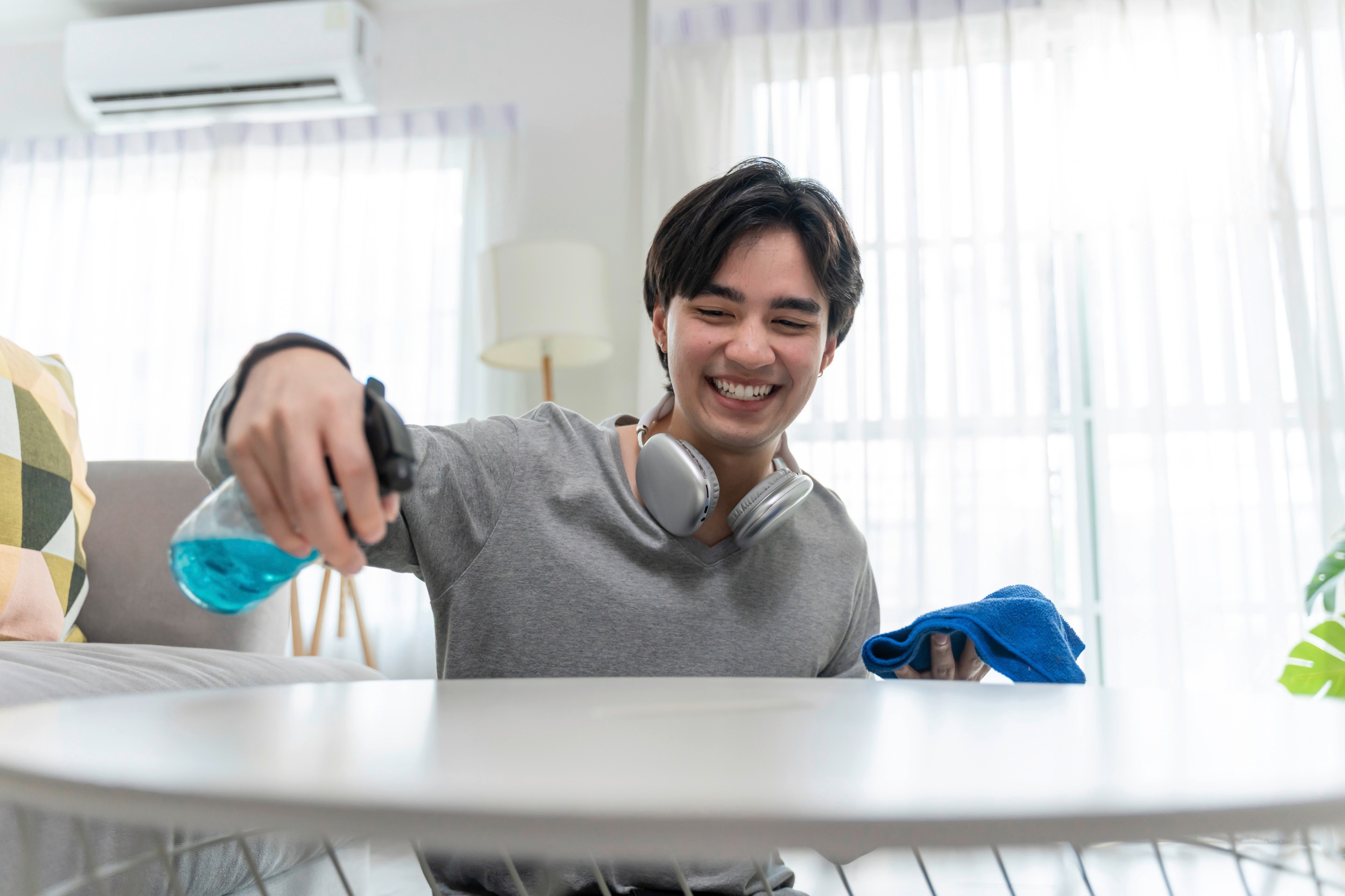 An Asian man cleaning a table.