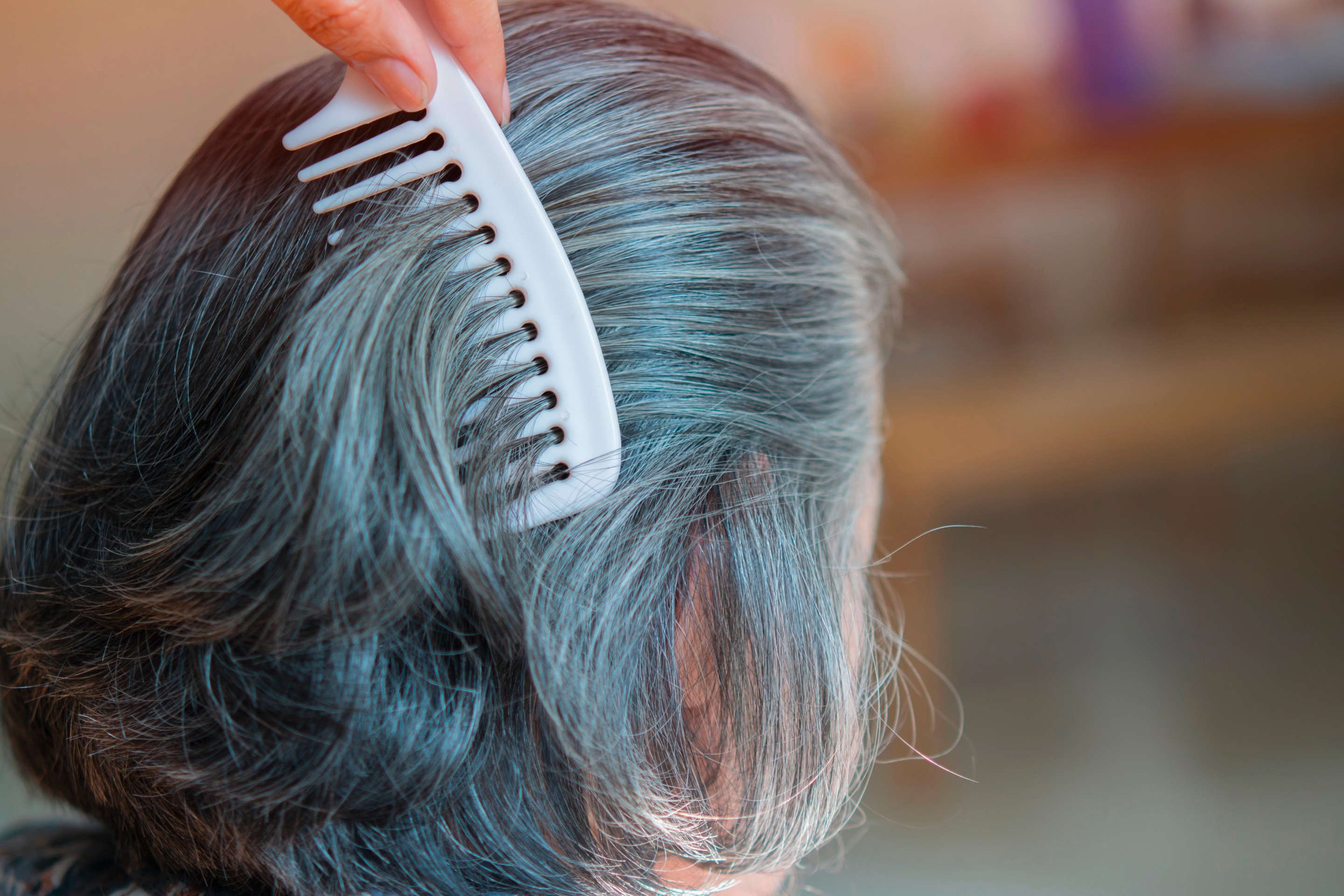 Woman combing her gray hair.