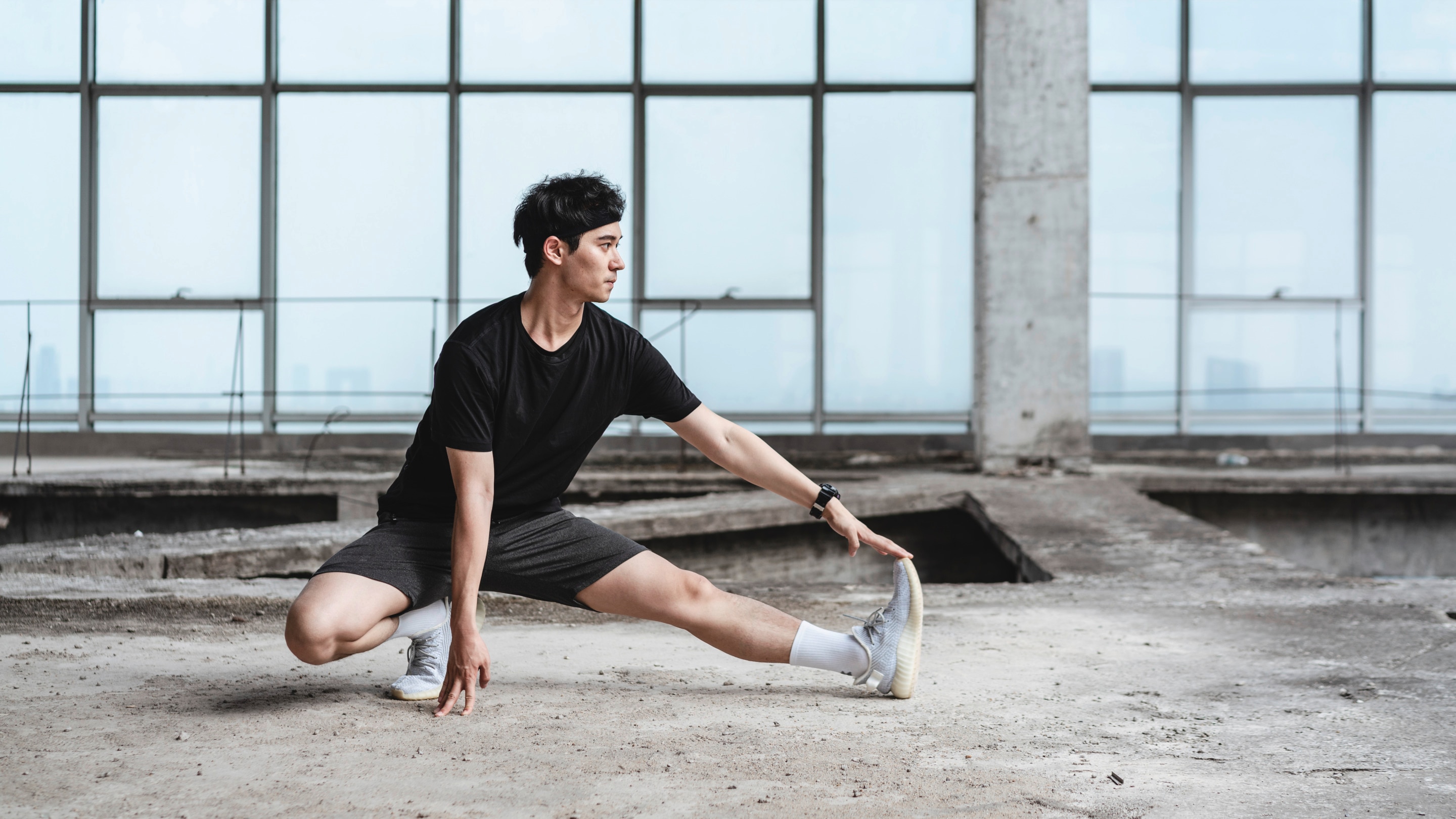 Pria Asia sedang melakukan peregangan kaki.