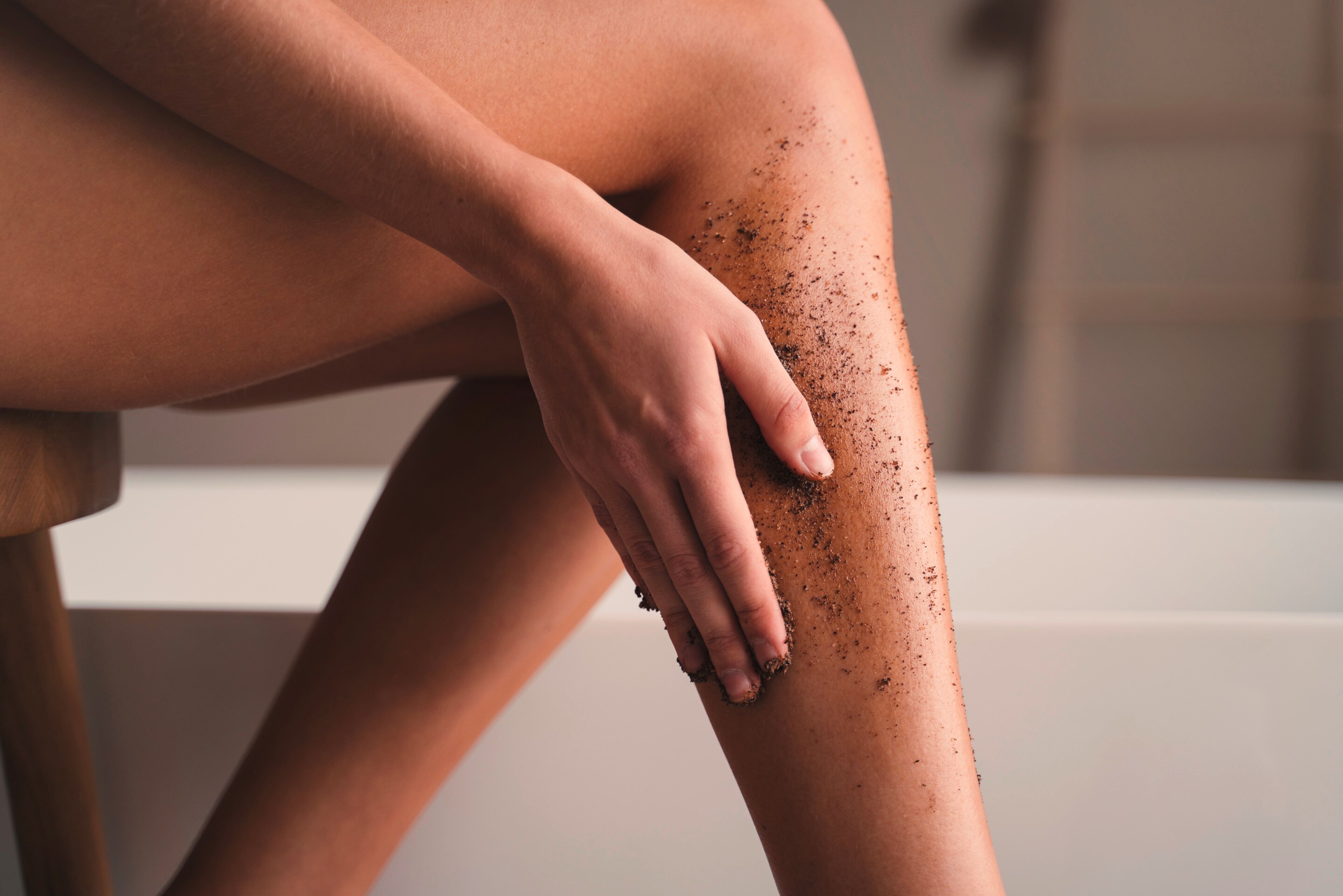 Woman’s legs with a body scrub slathered over it.