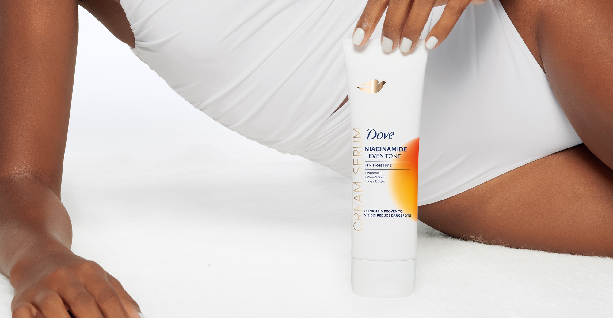 Product in-use with packaging image of the Dove Niacinamide Even Tone Cream Serum product