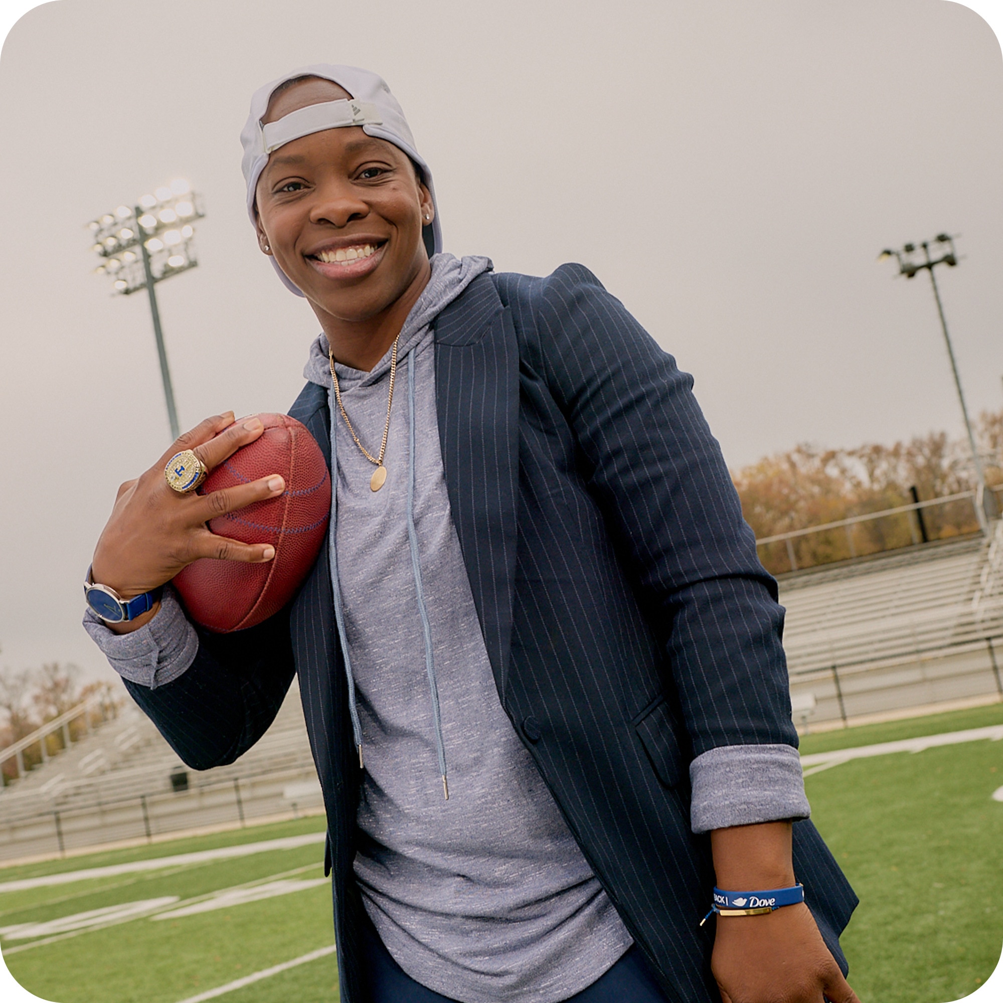 Odessa Jenkins smiling whilst holding a american football on a court