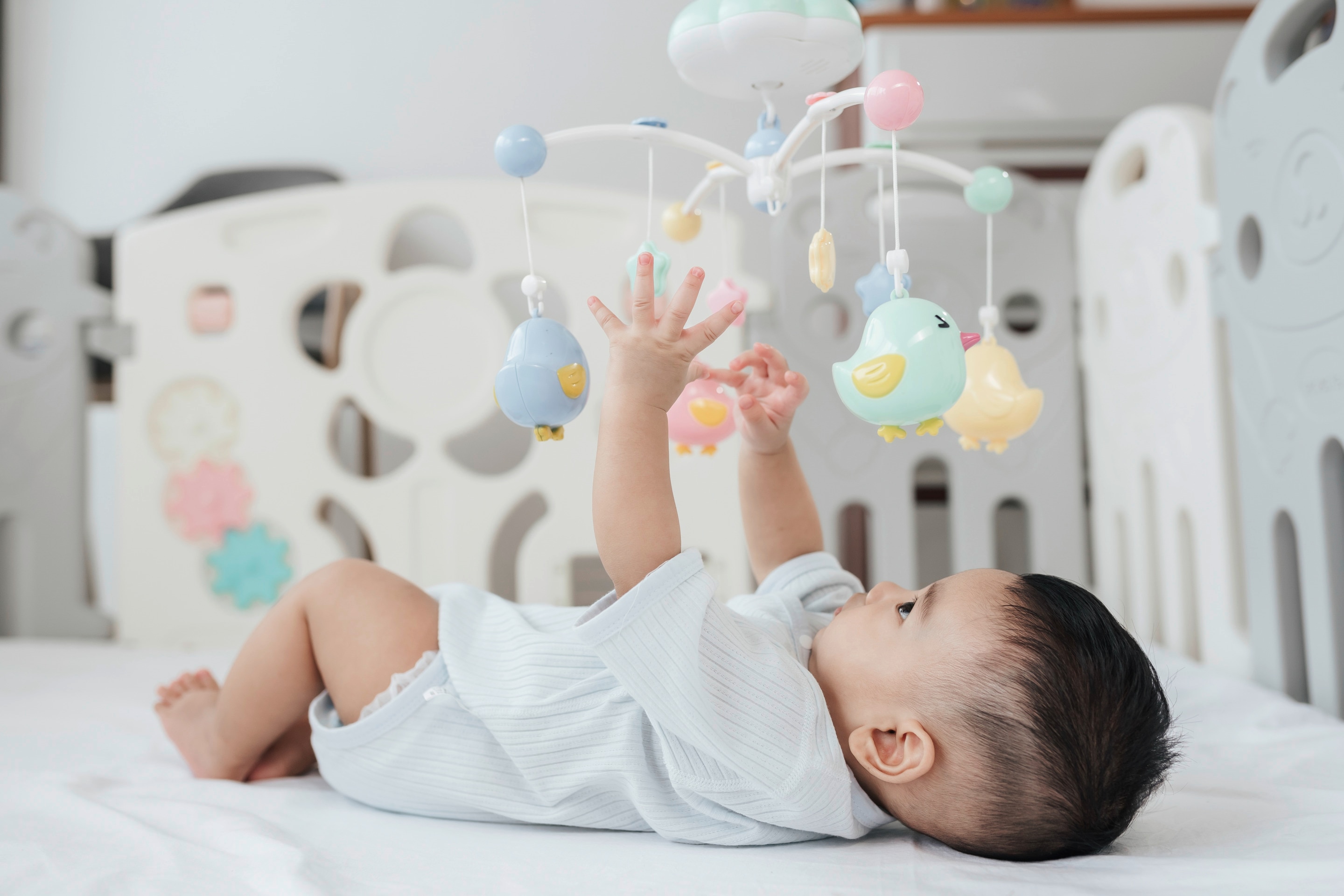 bayi usia 5 bulan yang sedang bermain untuk stimulasi perkembangan.