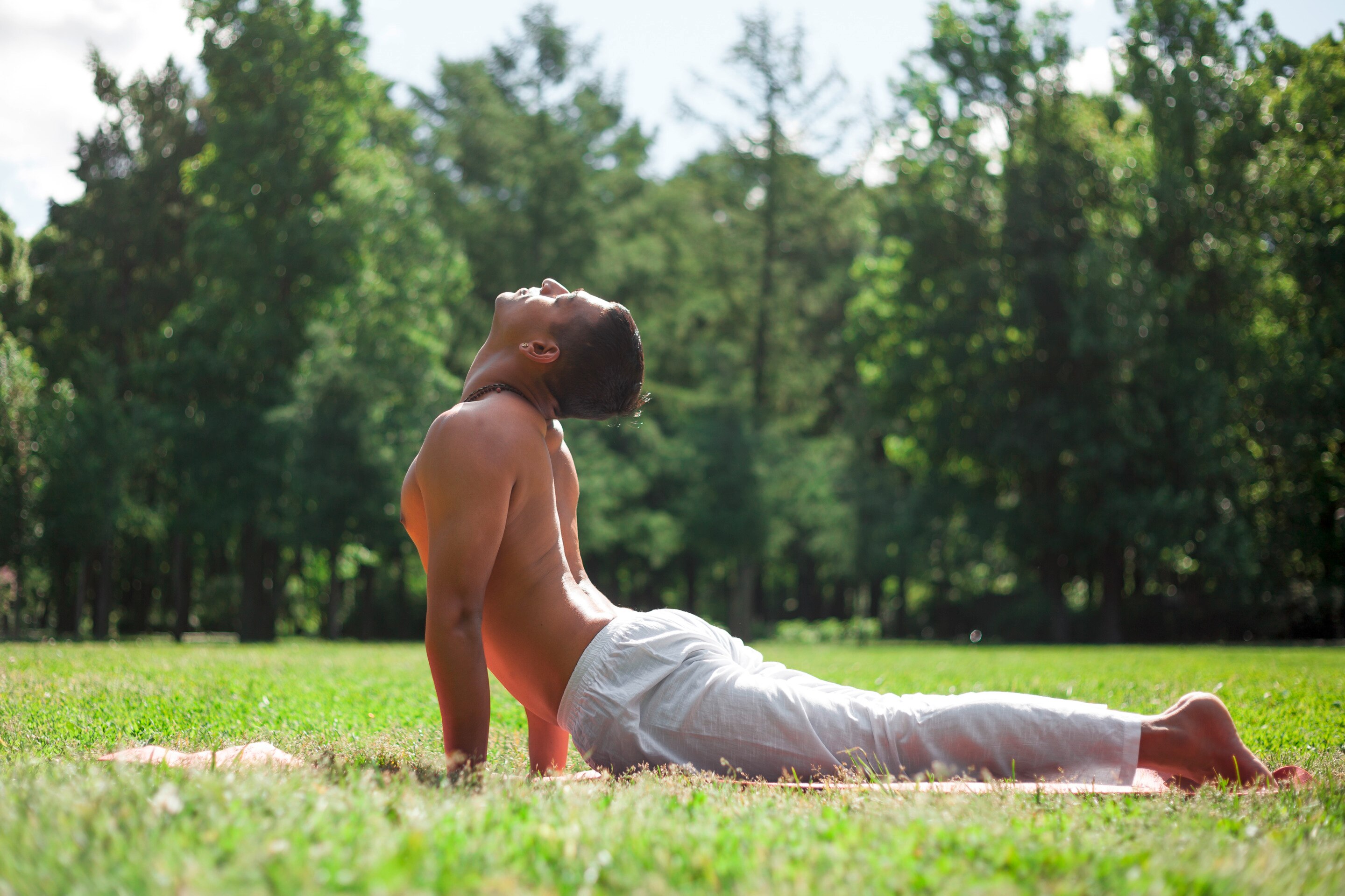 A man practices yoga in the middle of a field.