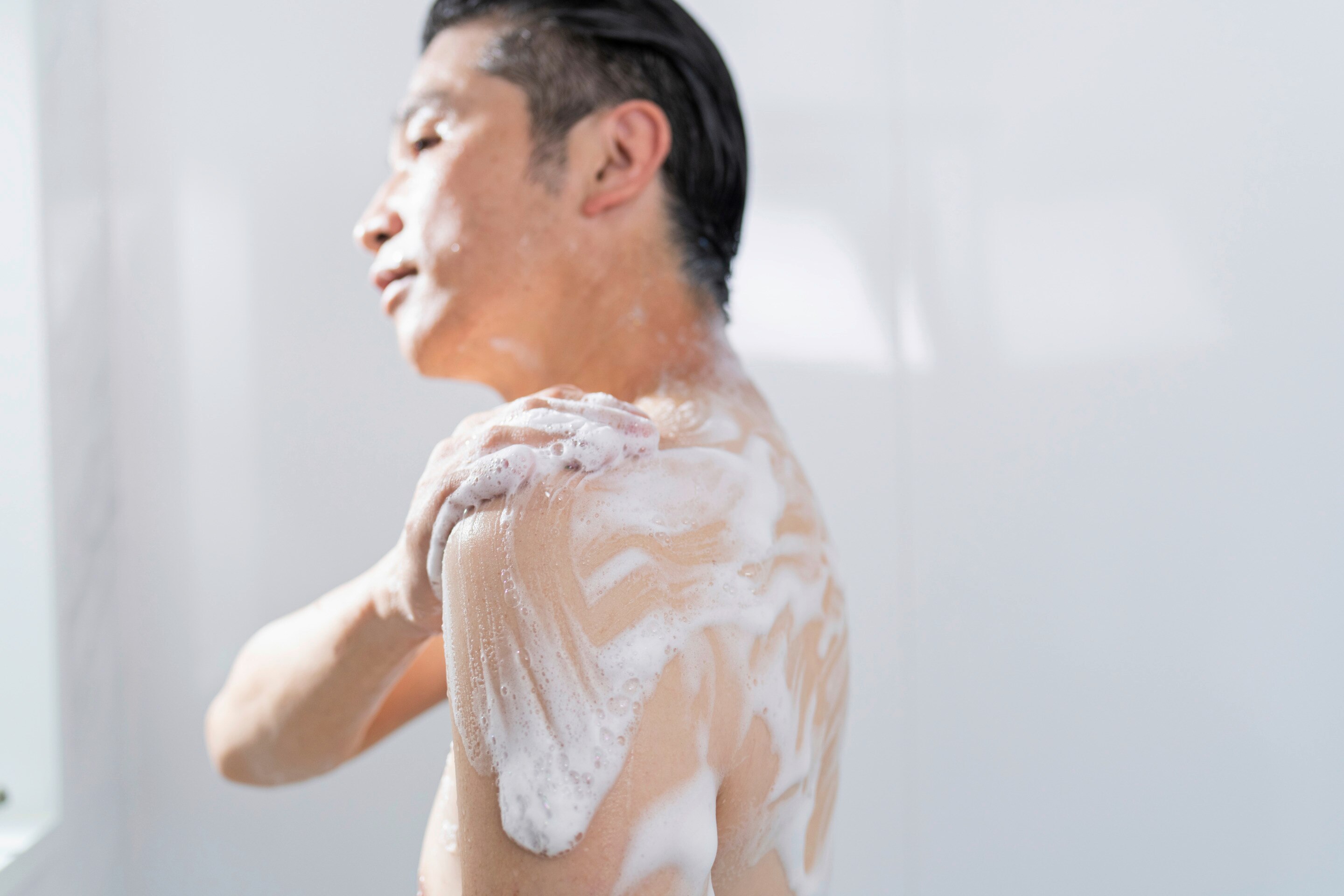 Man lathering soap on body.
