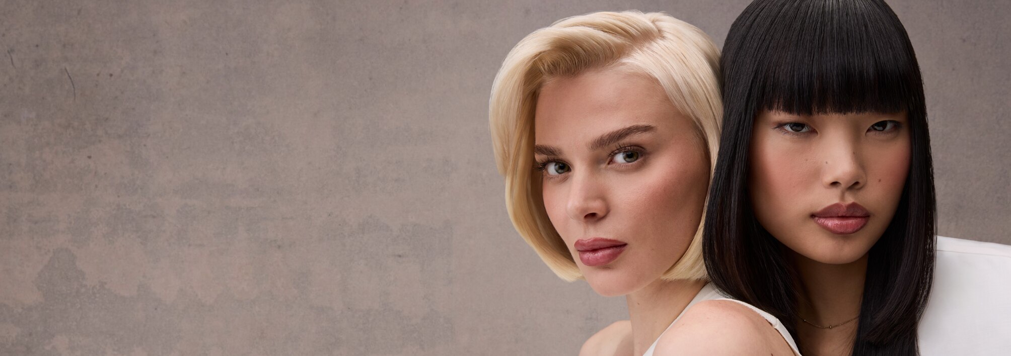 A contrasting hair duo featuring a sleek blonde bob and long, straight black hair against a neutral backdrop.