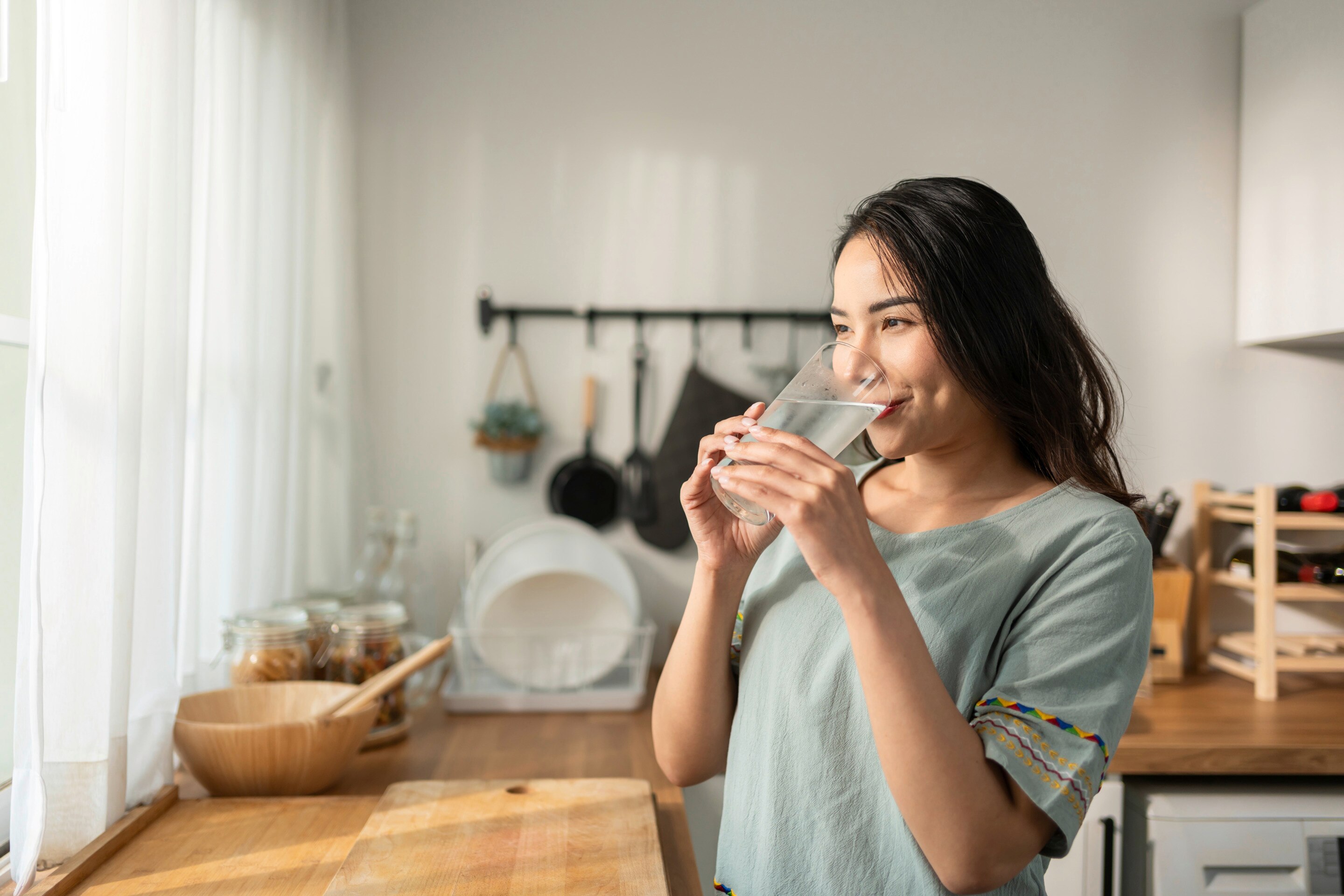 Woman smiling while drinking water.