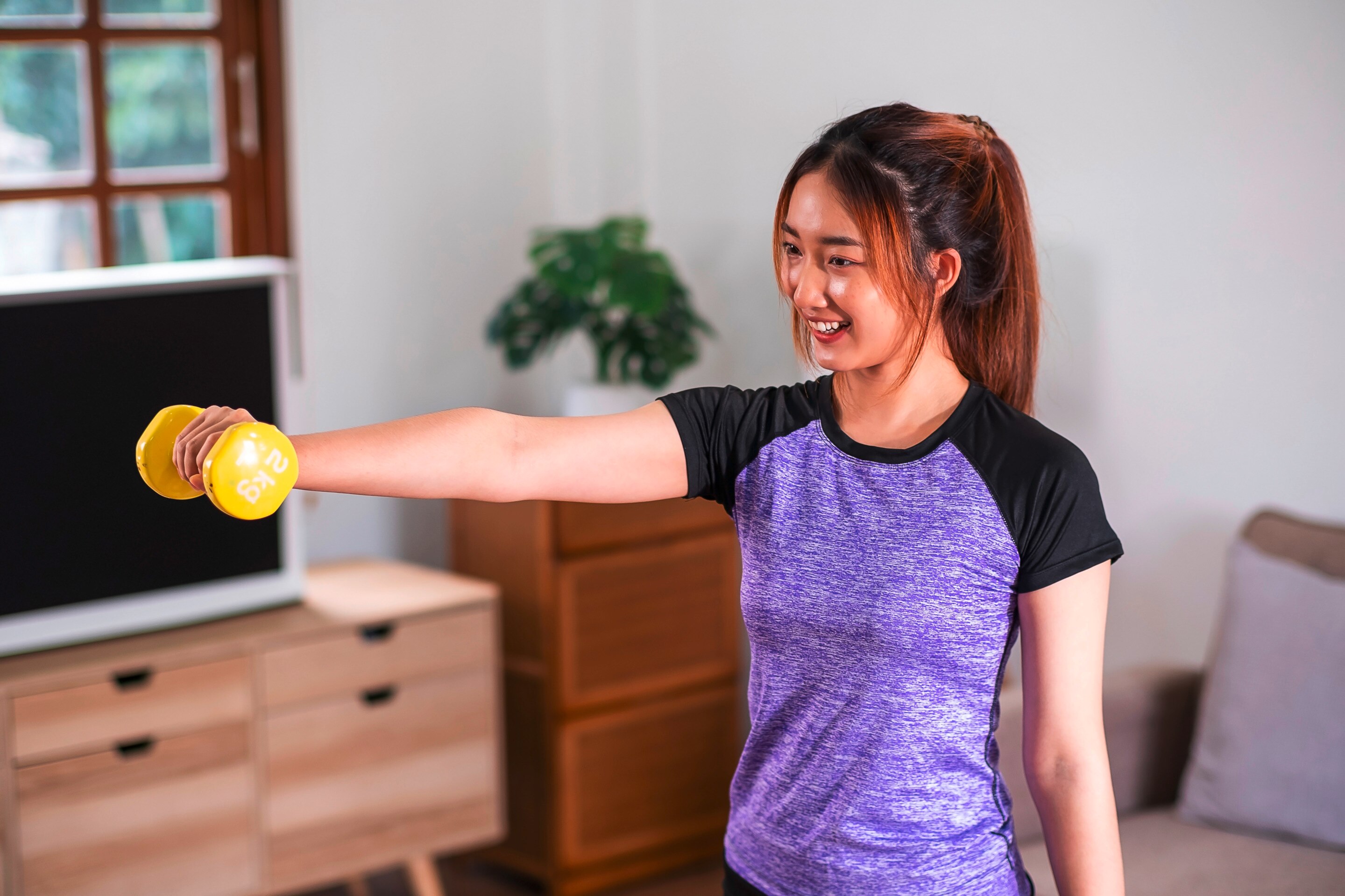 Woman working out with a dumbbell. 