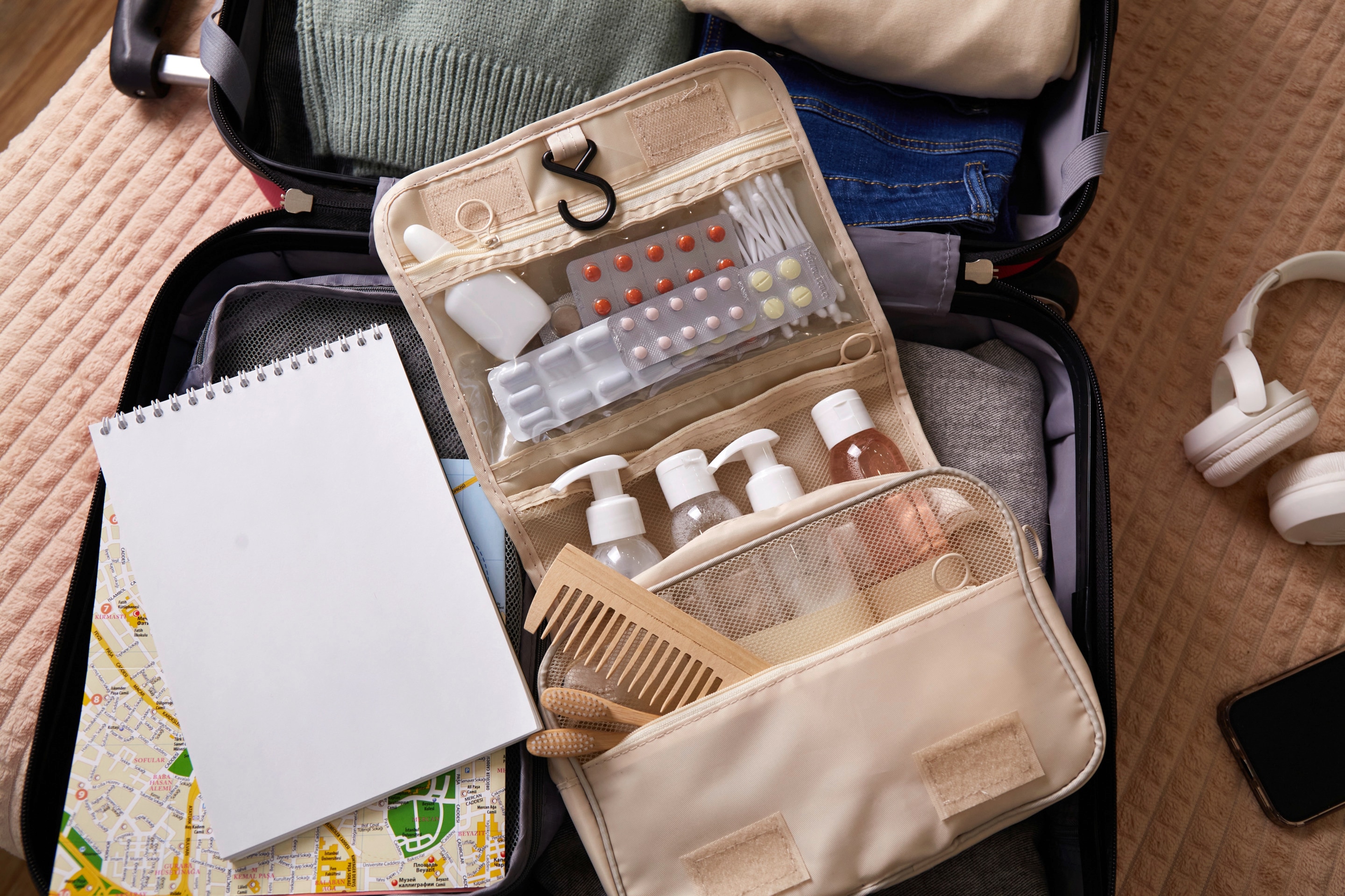 seseorang menunjukkan persiapan mudik dengan membawa koper dan tas perjalanan.