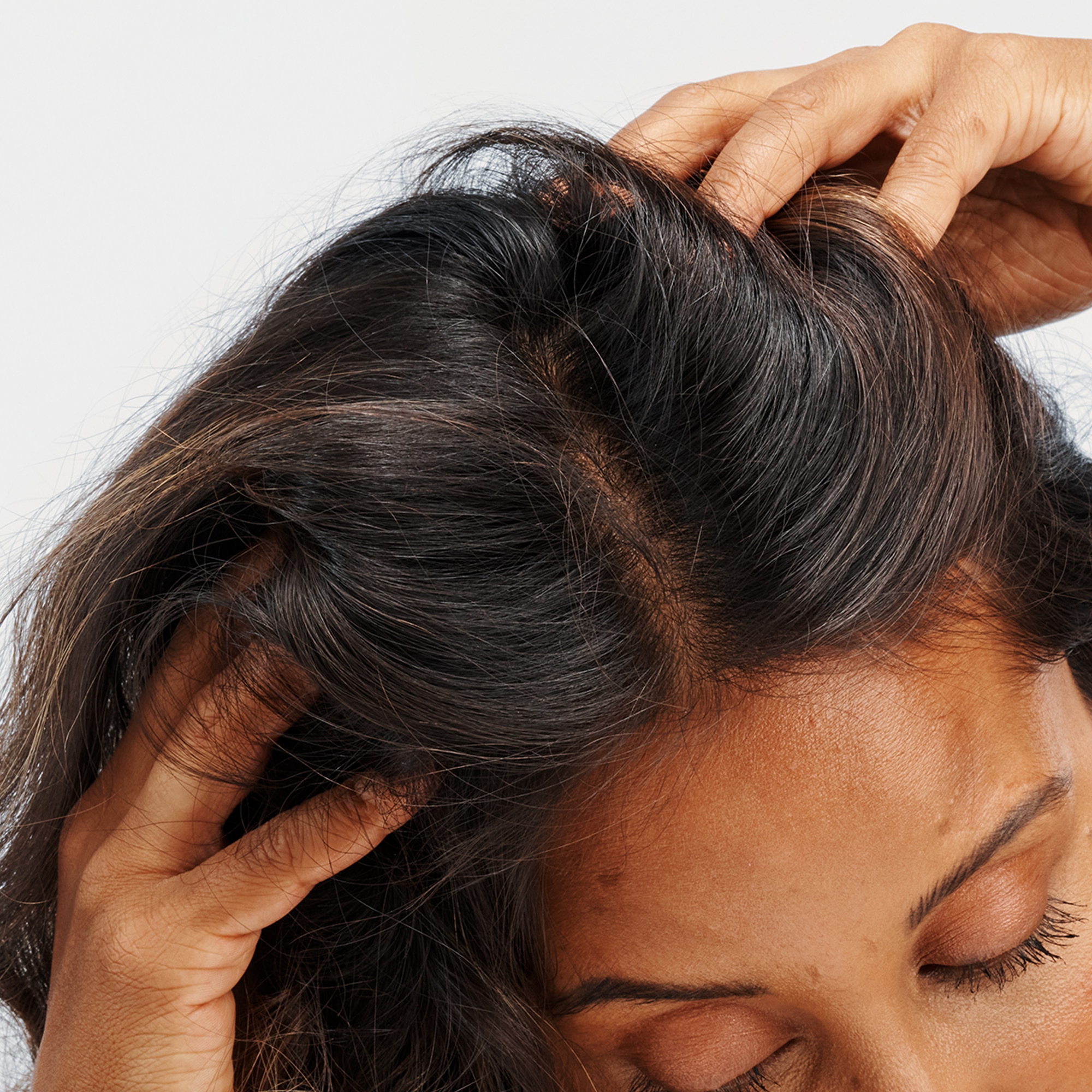 Close up of woman with hands in hair 
