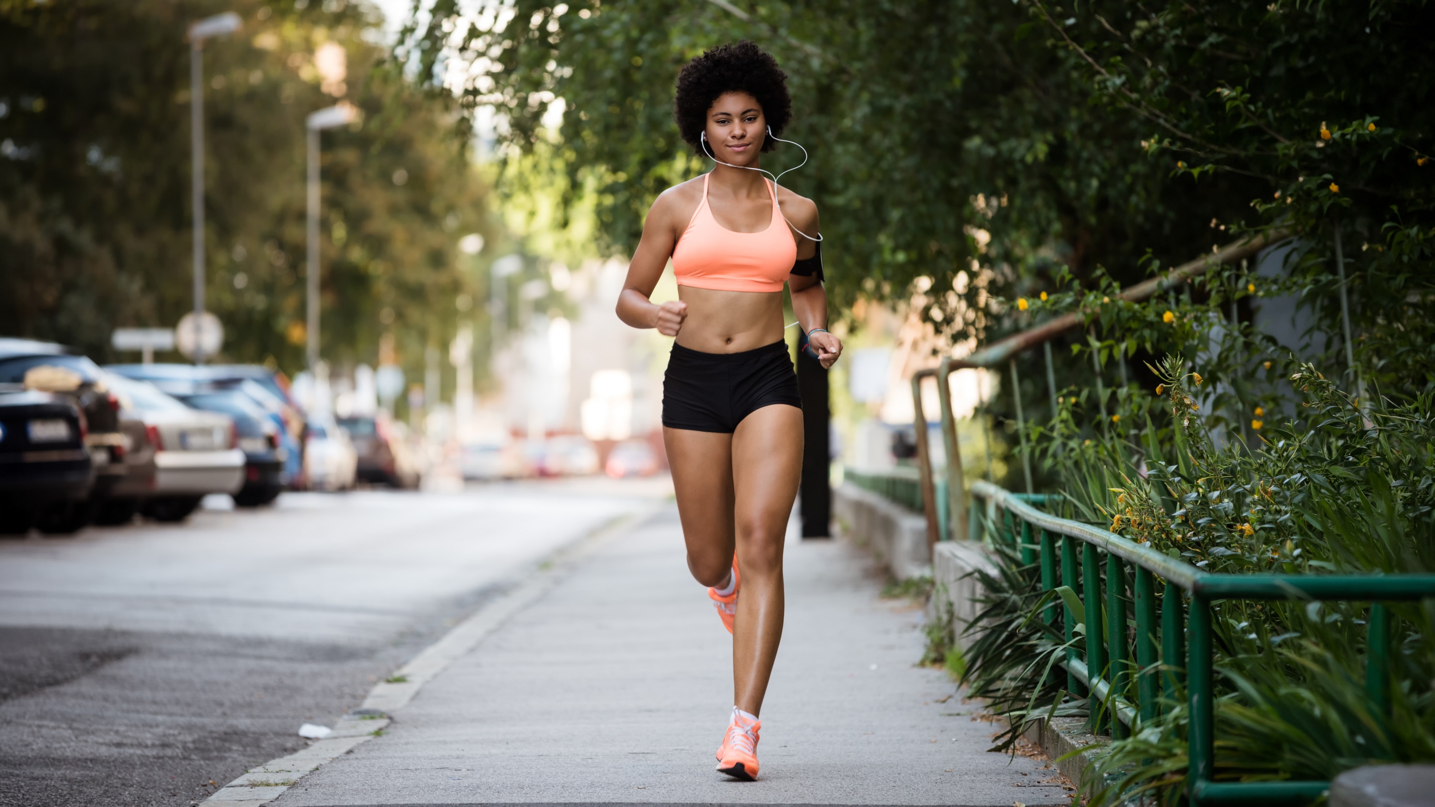 Young woman running in shorts while wearing whole body deodorant to prevent chafing