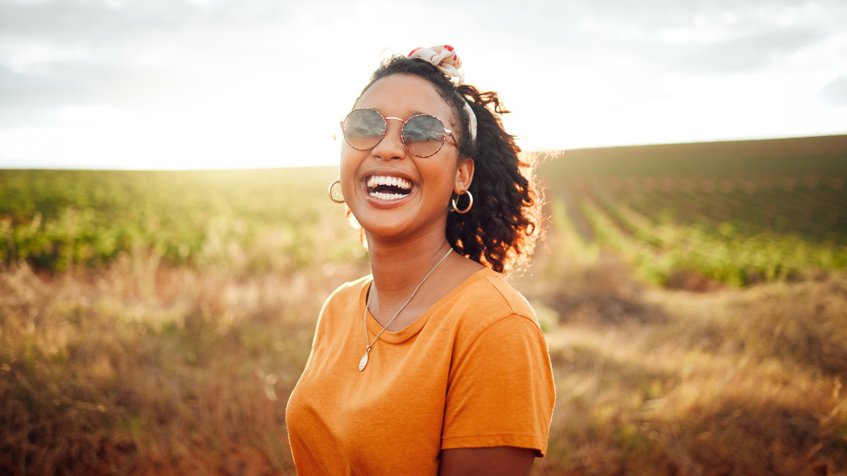 Happy African American woman enjoying a summer walk after improving her skin water retention and barrier 