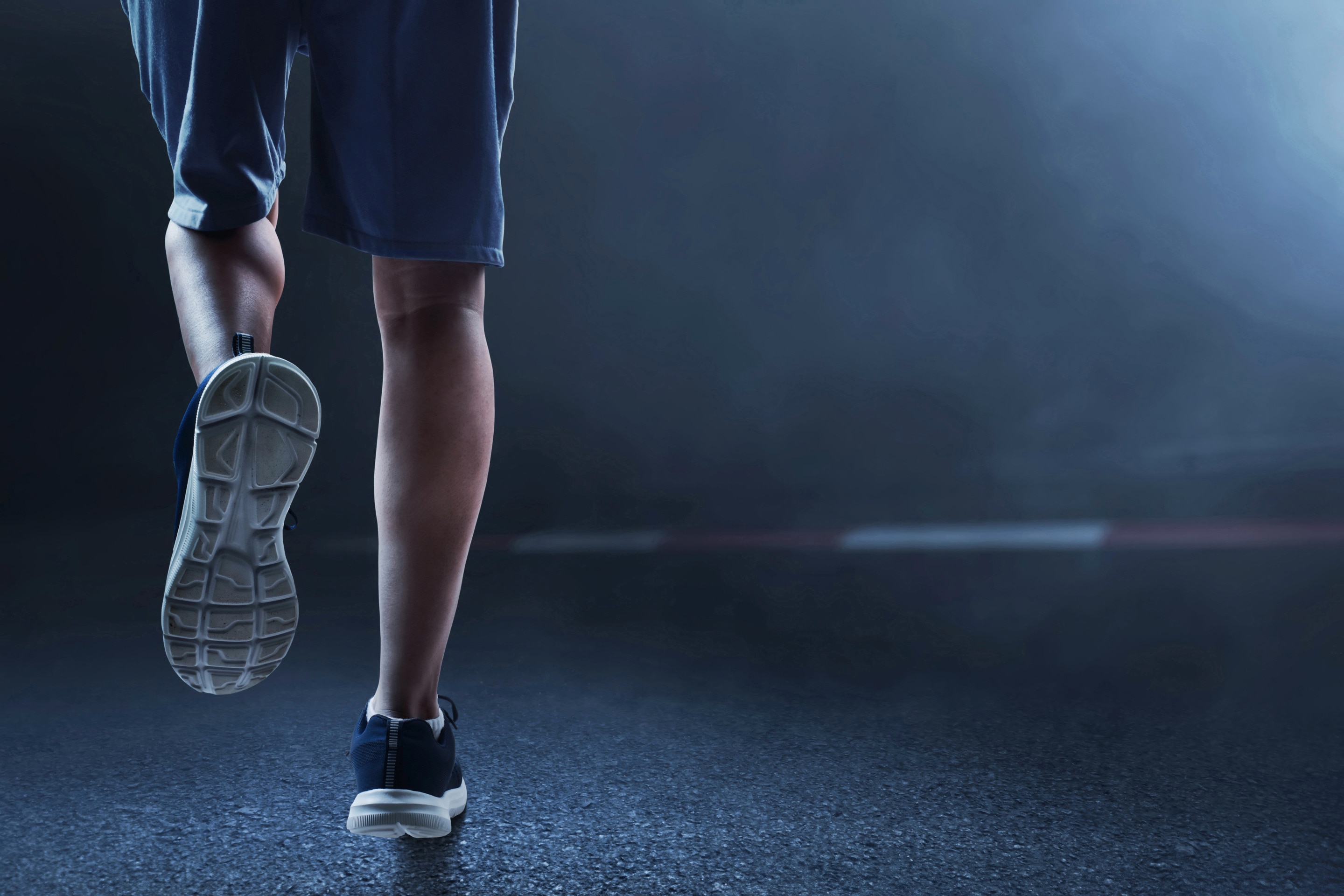 ada pria sedang berlari dengan sepatu running untuk olahraga malam.